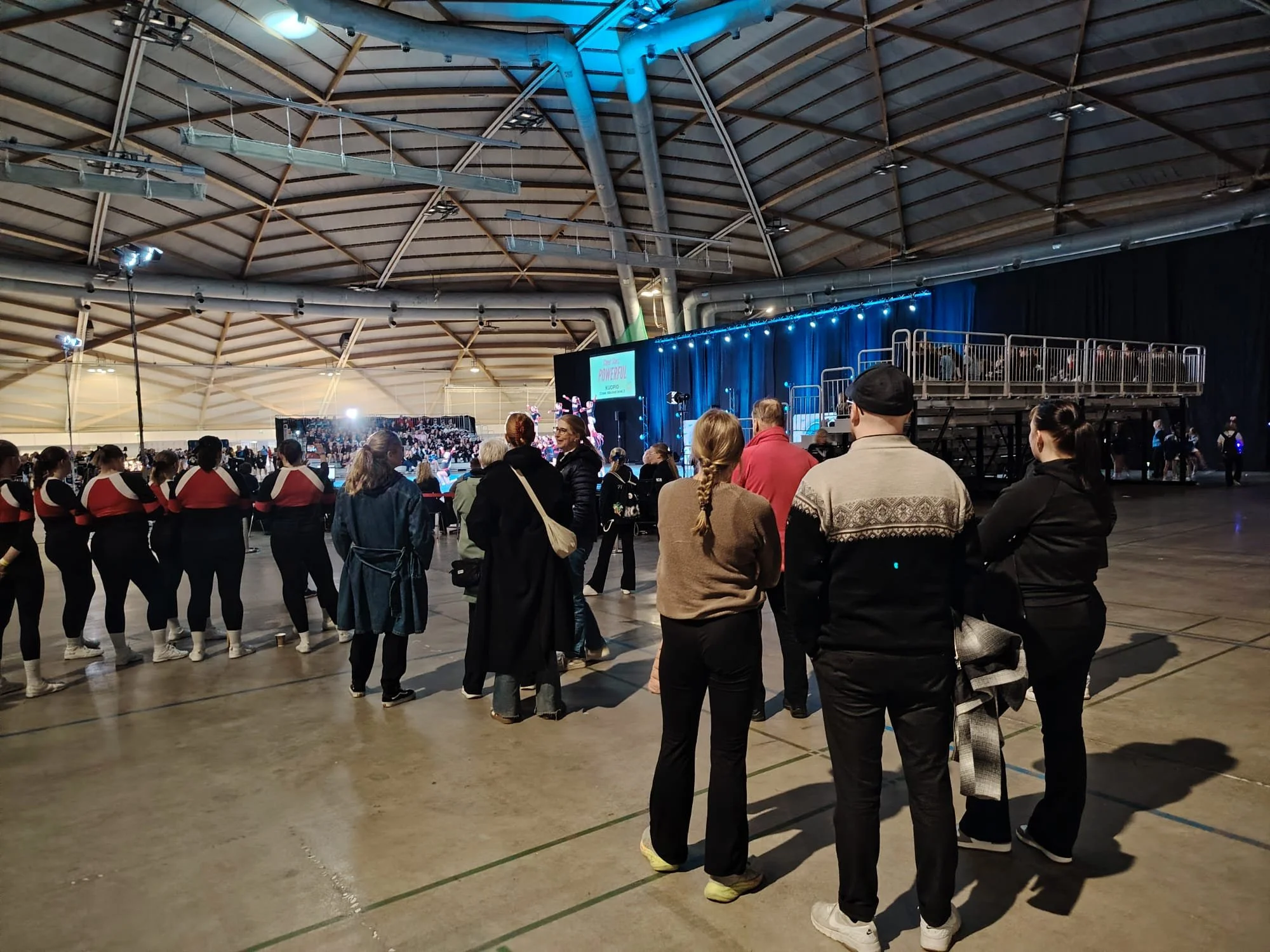 People watching to the stage in indoor sports arena.