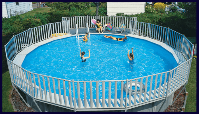 Large above ground swimming pool with surrounding wall and fence panels forming part of the safety barrier.