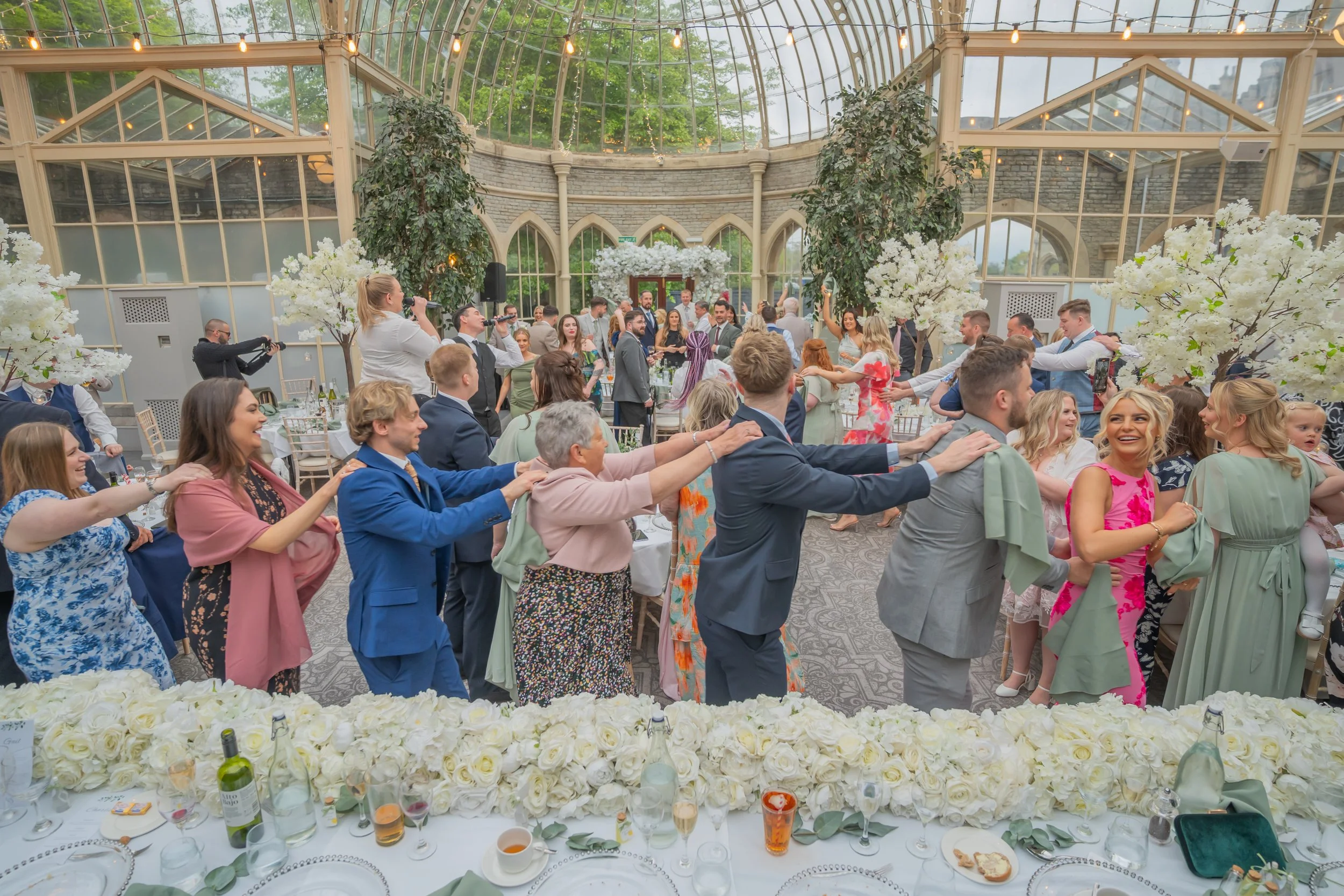 Guests enjoying a lively conga line during the evening reception at Tortworth Court.jpg