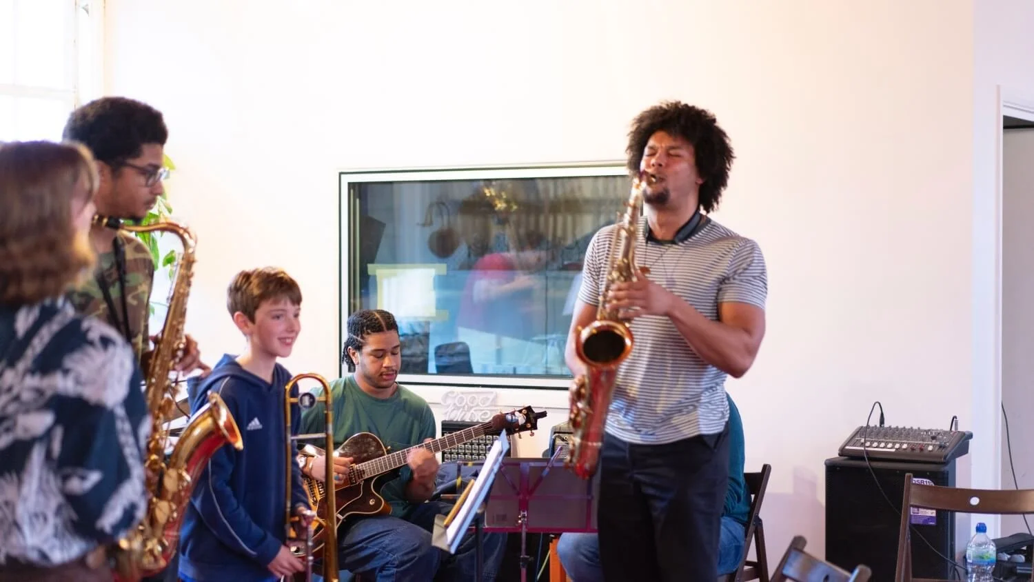 Tutor demonstrating saxophone to class.