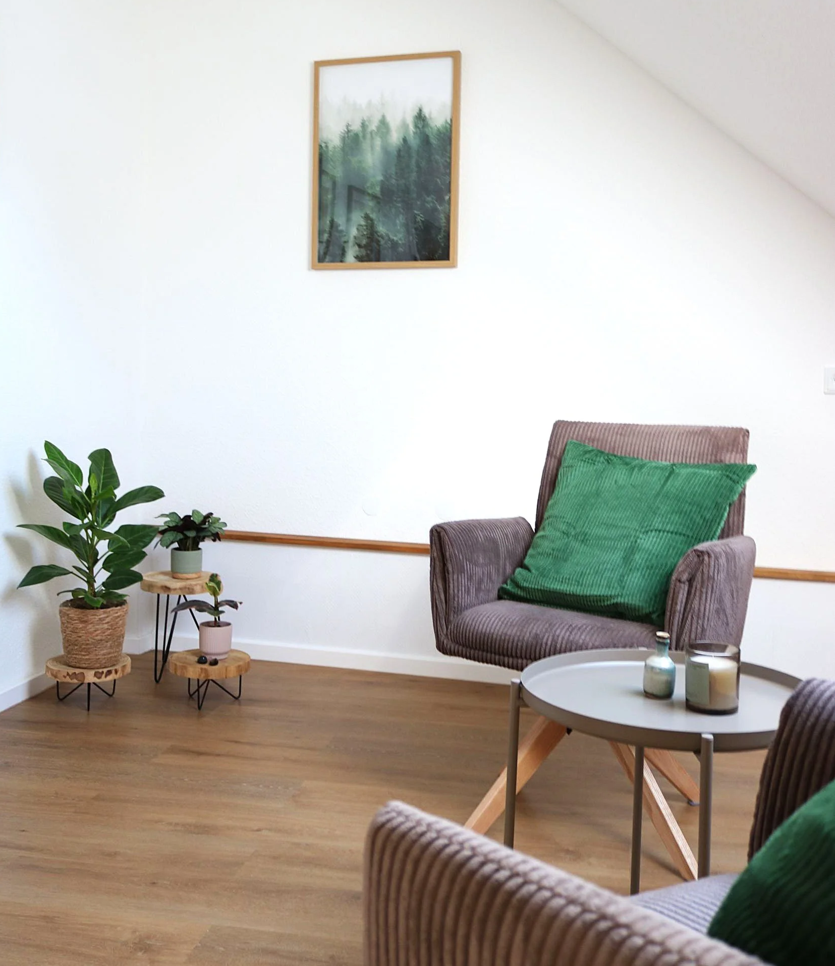 Coaching Praxisraum in Hamm (Sieg) mit grünen Pflanzen, beigen Cordsesseln und einem Waldbild an der Wand.