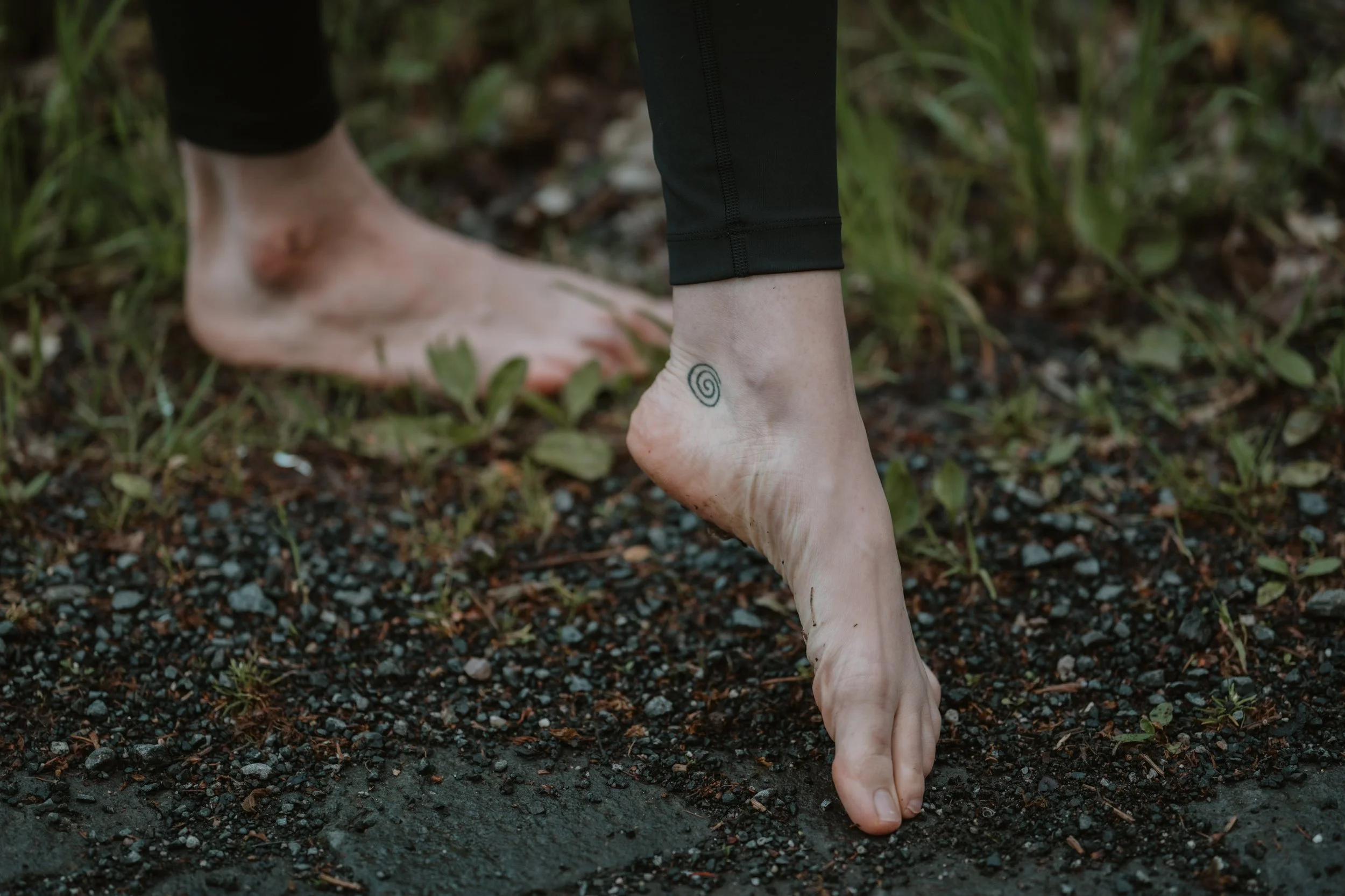 Barfüßige Füße auf natürlichem Untergrund als Symbol für Erdung und bewusste Körperwahrnehmung im Somatic Yoga.