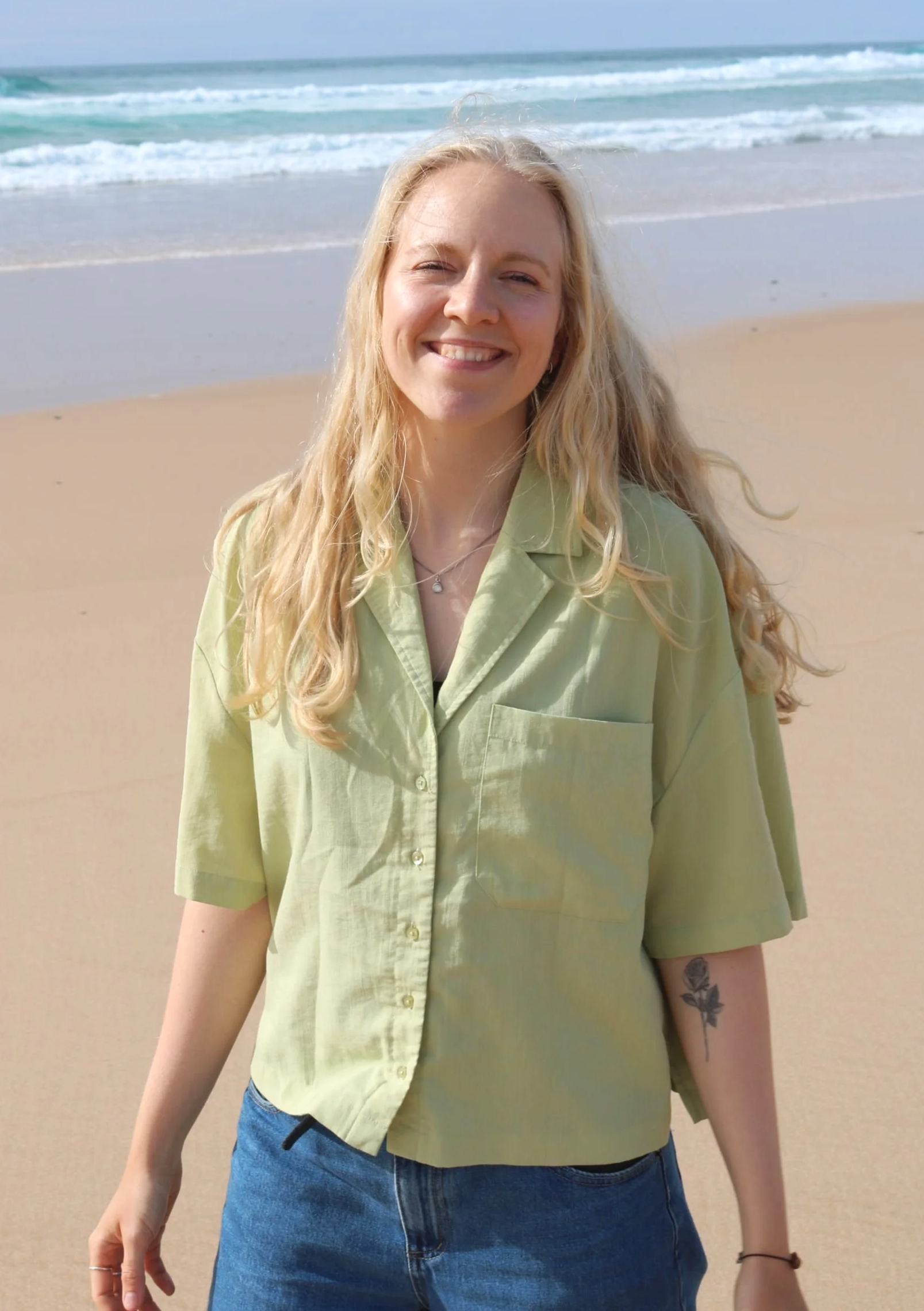 Leona Roes lächelt in die Kamera auf einem Strand in Portugal.