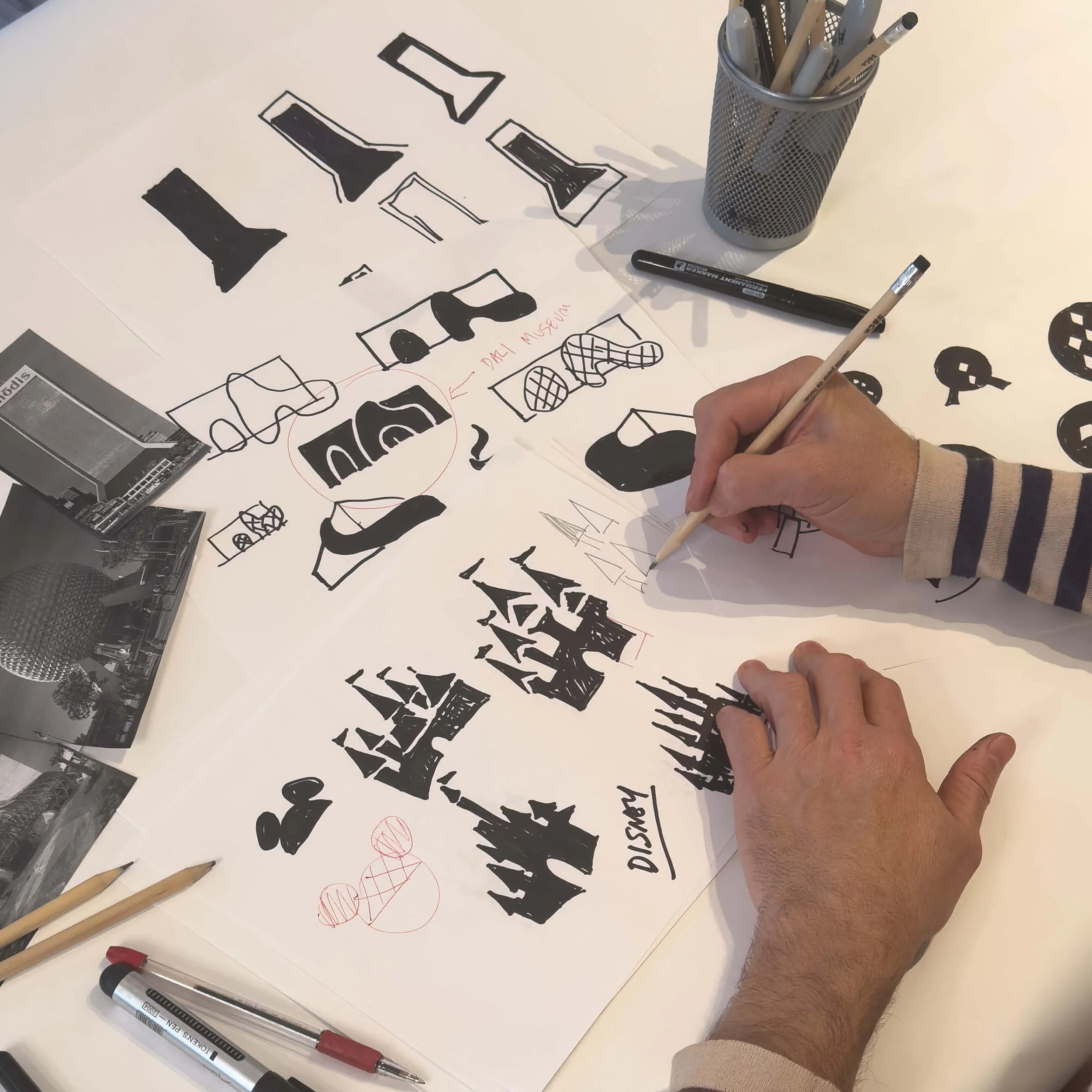 Process image showing the hand-drawn development of several Florida icons, including studies and revisions for landmarks such as Disney and the Dalí Museum.