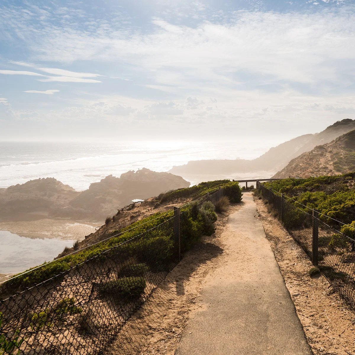 A golf course with several sand traps and a clubhouse in the background.
