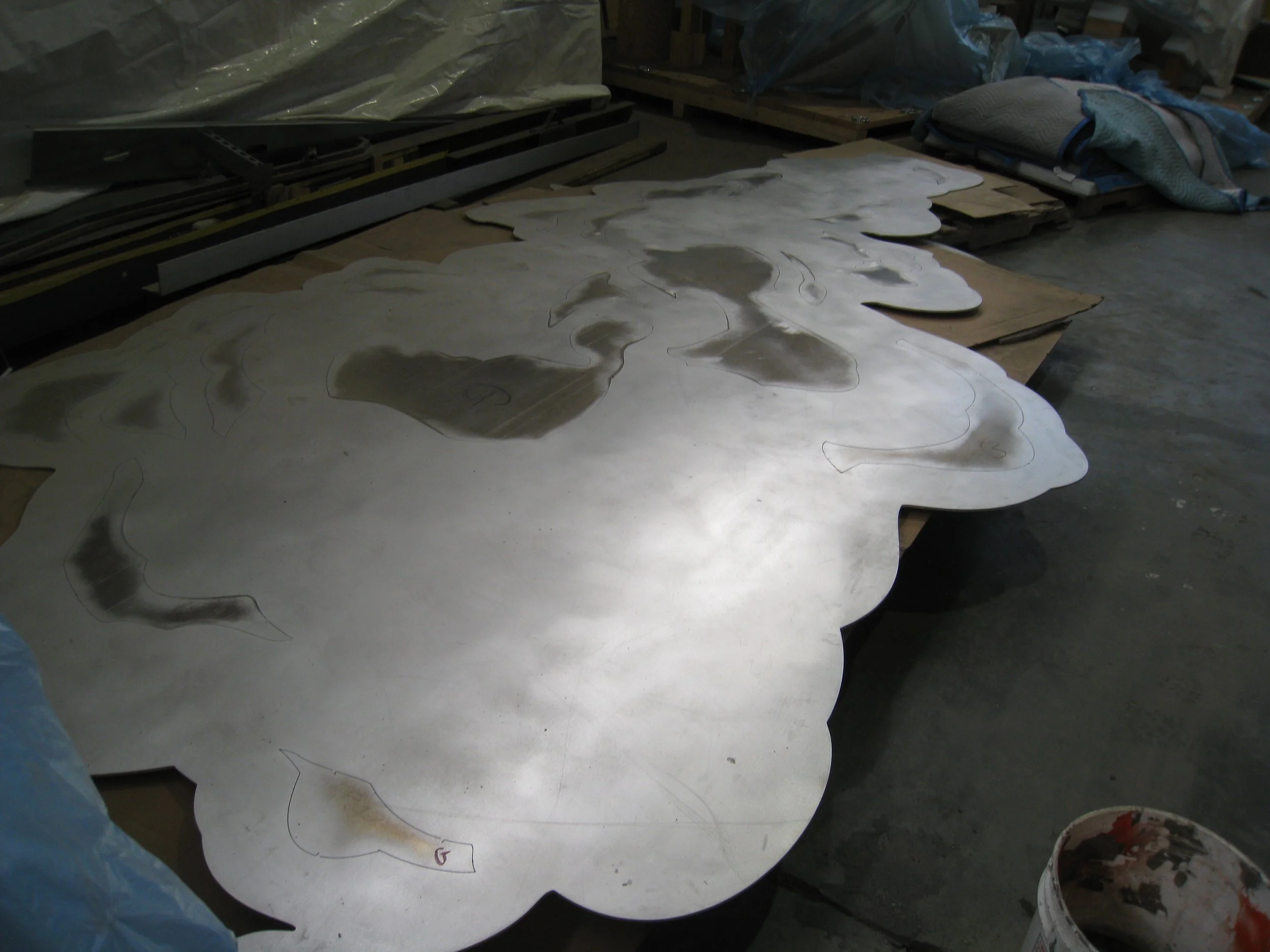 This is what they pieces look like when they arrive from the company that did the water jet cutting. Mike left the negative spaces tacked in when rolling the pieces because it helps keep the bending consistent.