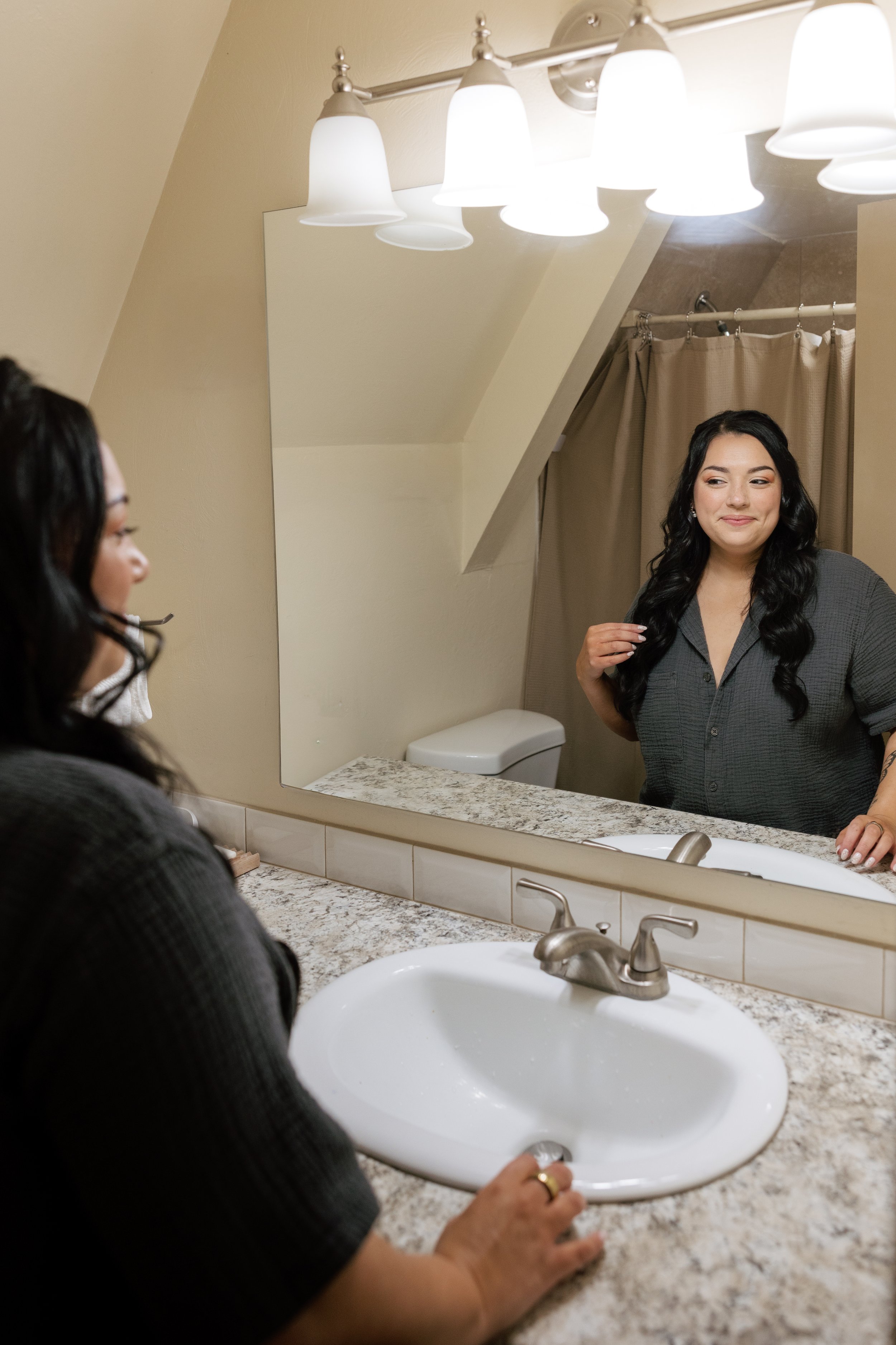 bride admiring her bridal hair and make up before getting into her wedding gown