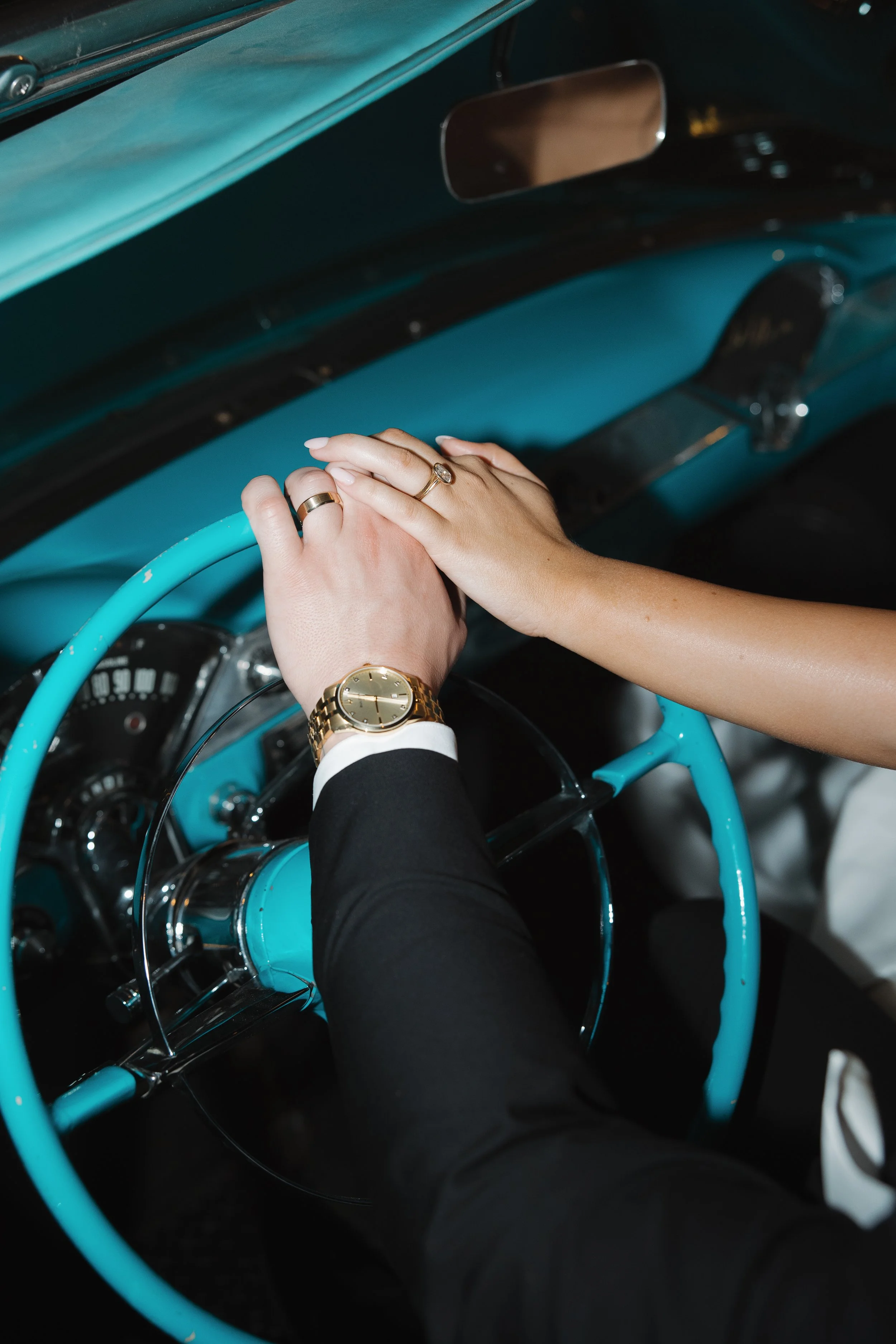 Bride and groom showing their wedding rings inside vintage car outside The Canal Club at The Scott Resort & Spa in Scottsdale, Arizona