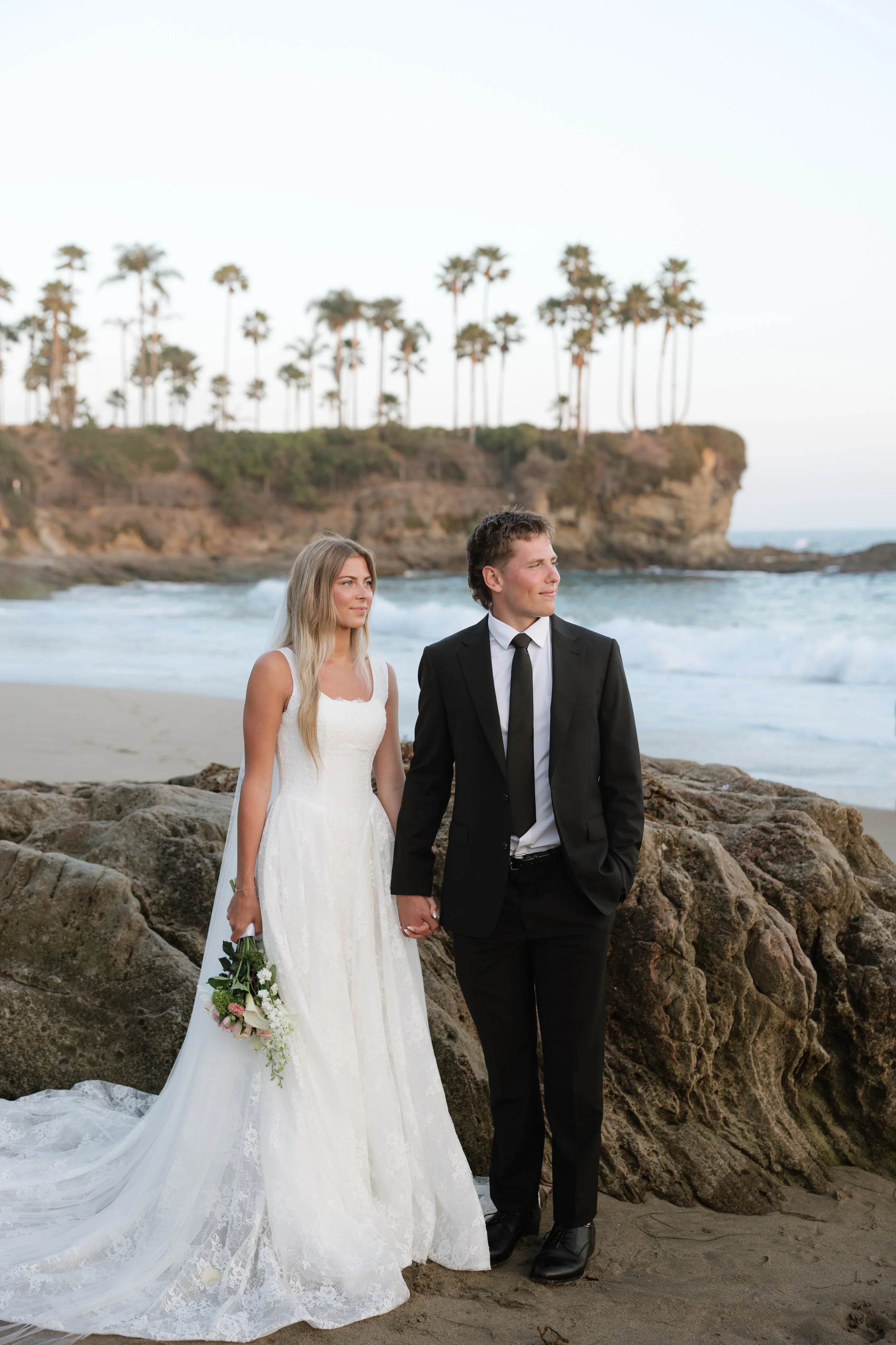 bride and groom looking out over the ocean in southern california