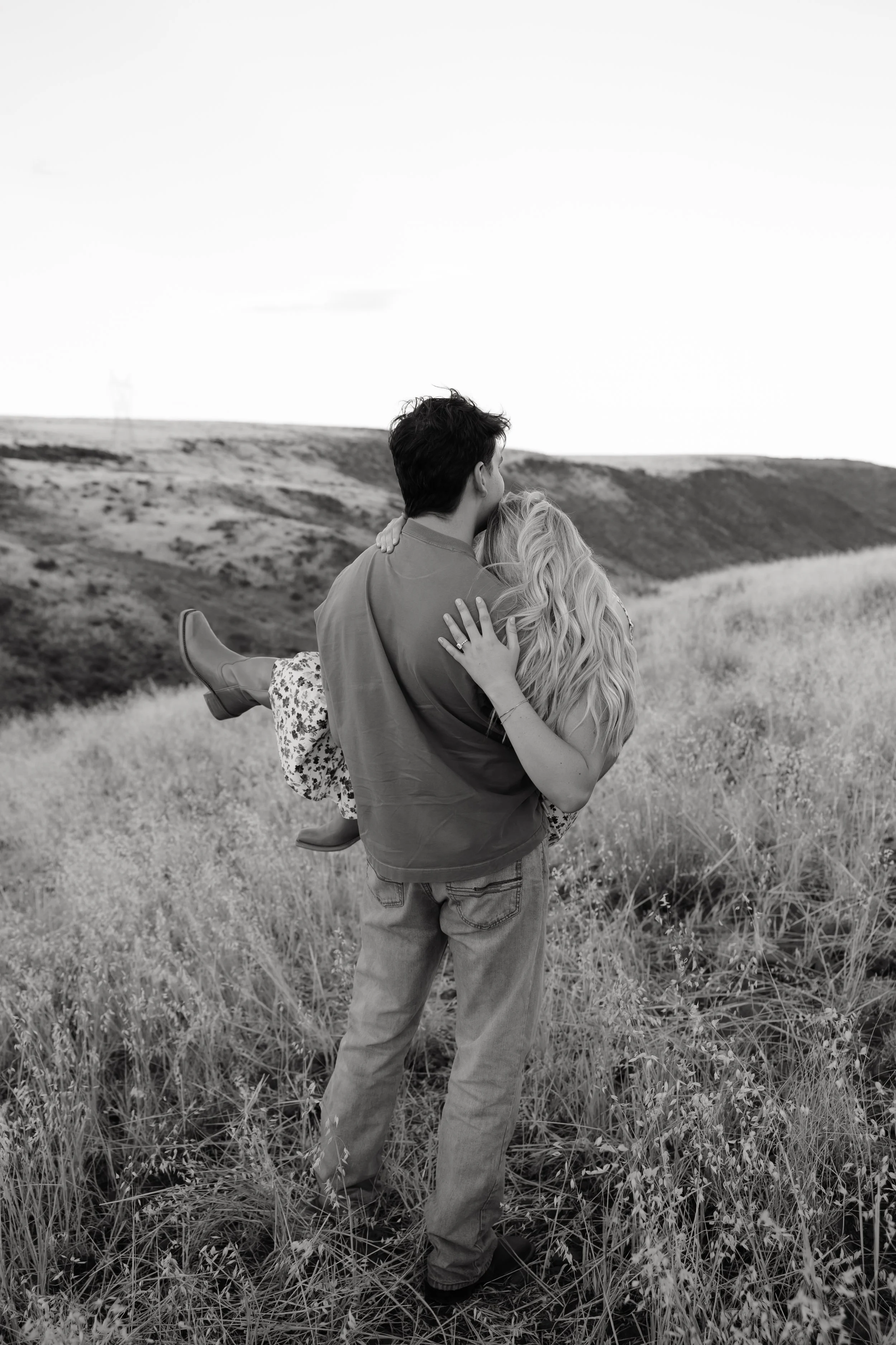 Candid engagement photo of a couple overlooking desert hills in Arizona