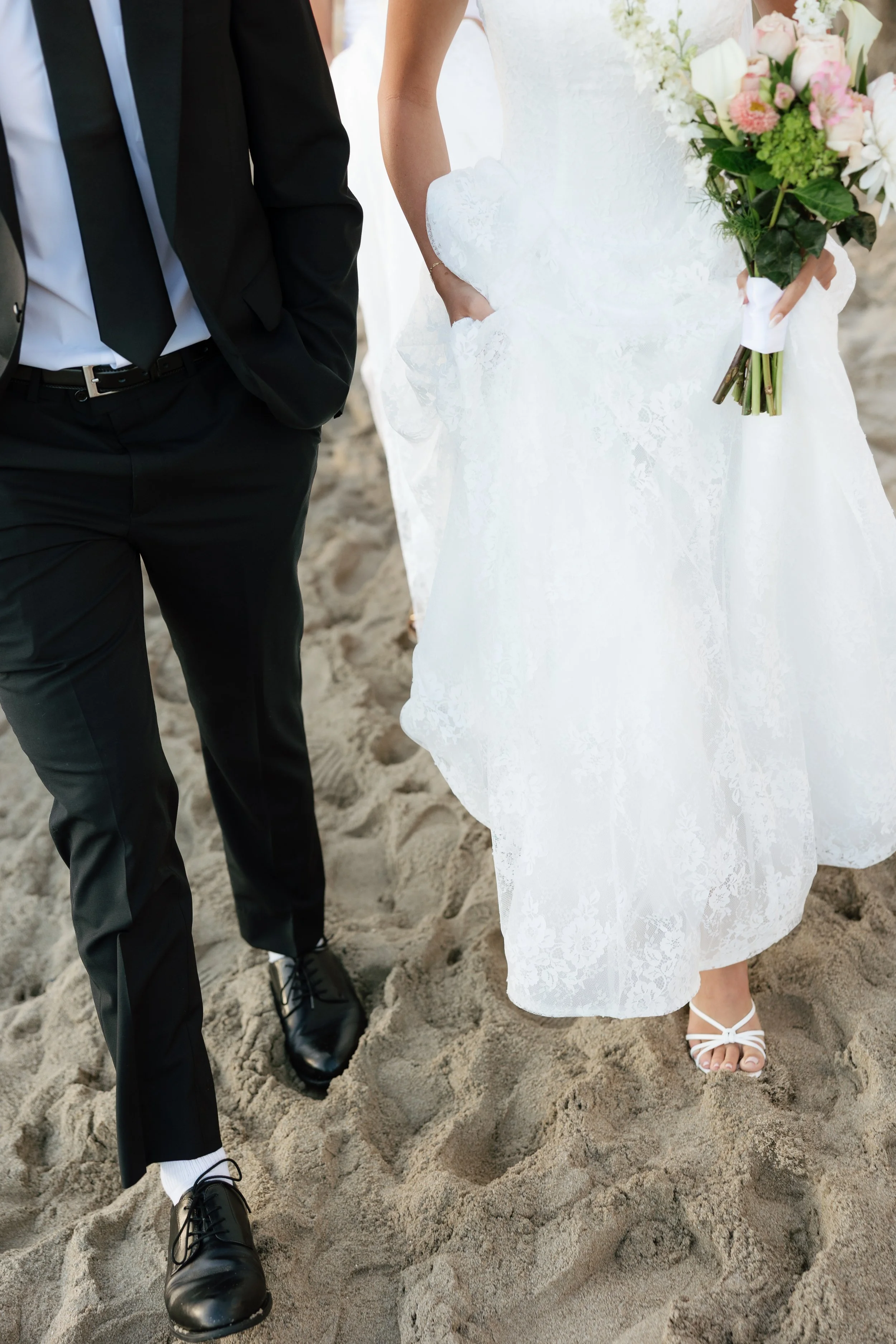 bride and groom walking on the beach in laguna beach