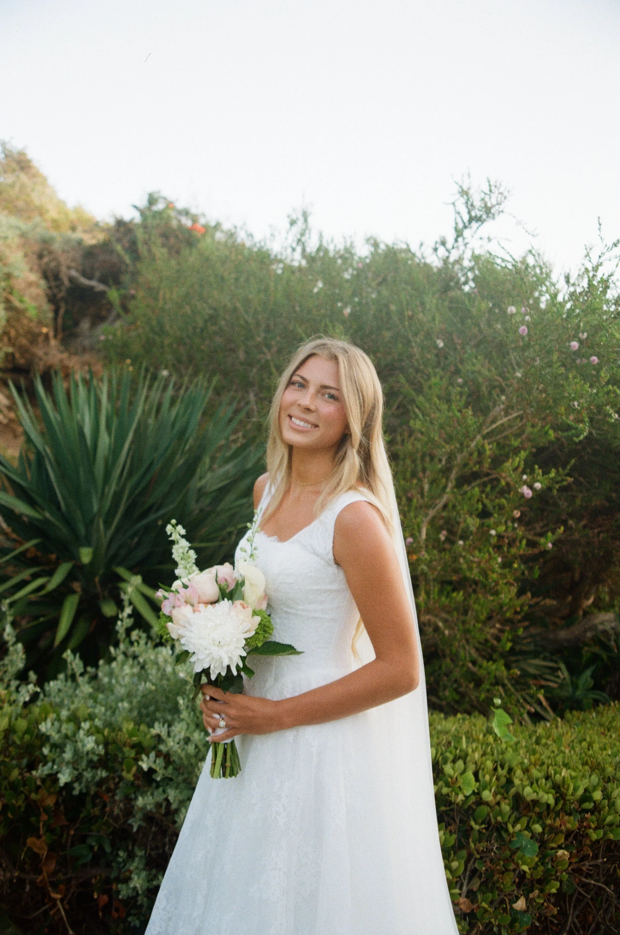 film photo of a bride holding a bouquet at her first look in laguna beach california