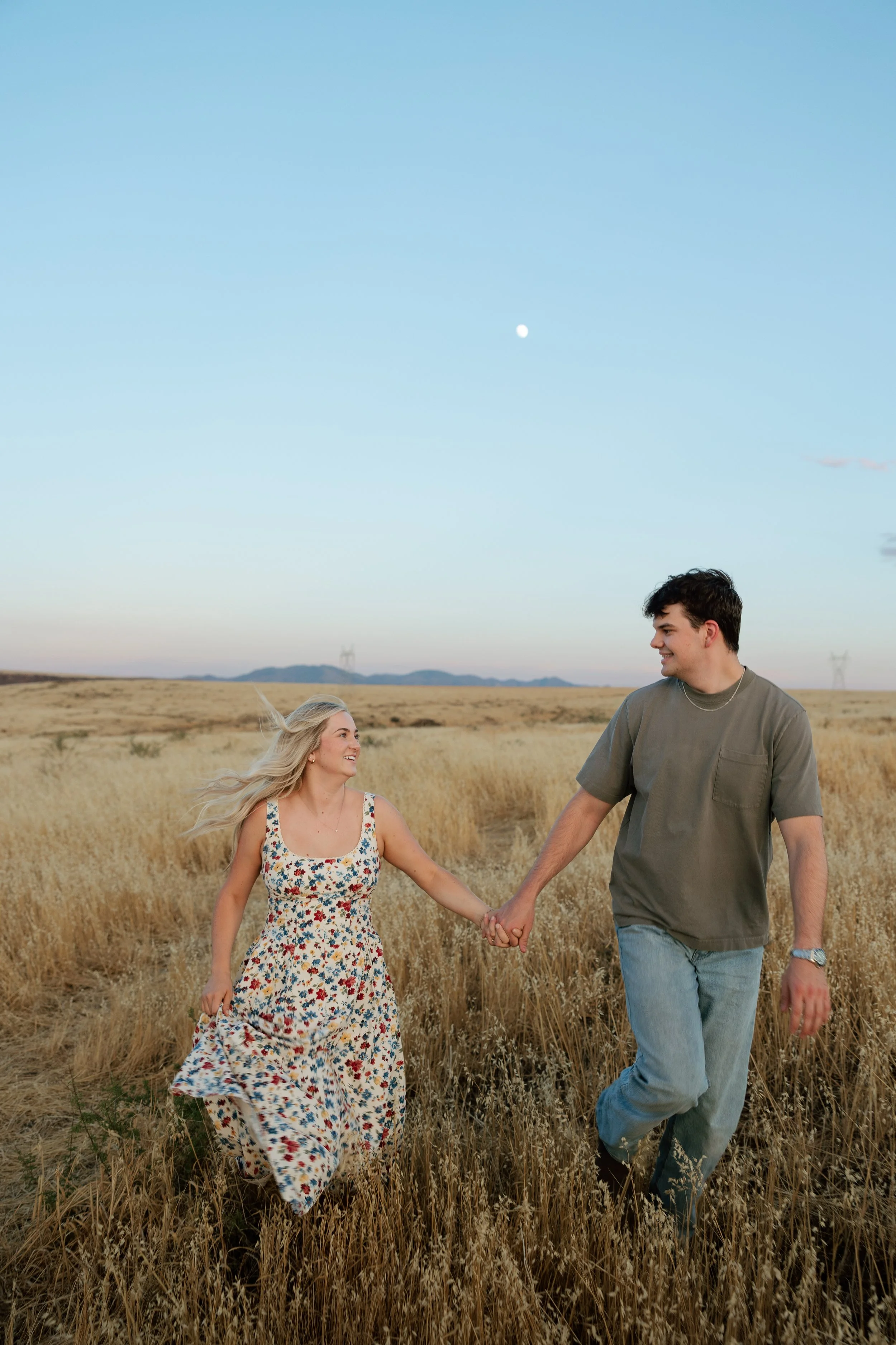 Arizona engagement photographer capturing a couple among golden grasslands at sunset