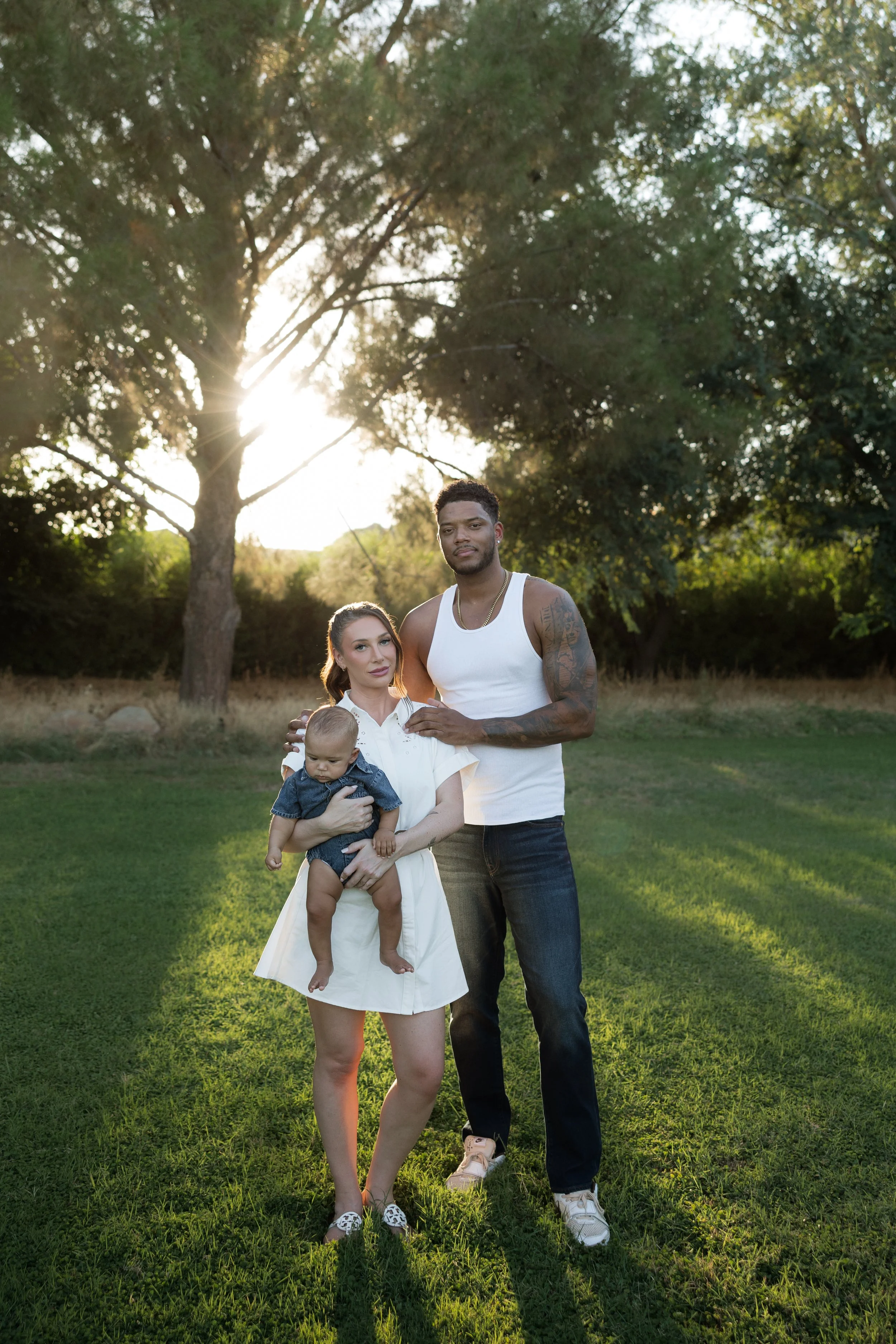 Young family embracing outdoors during a golden hour portrait session in queen creek, arizona