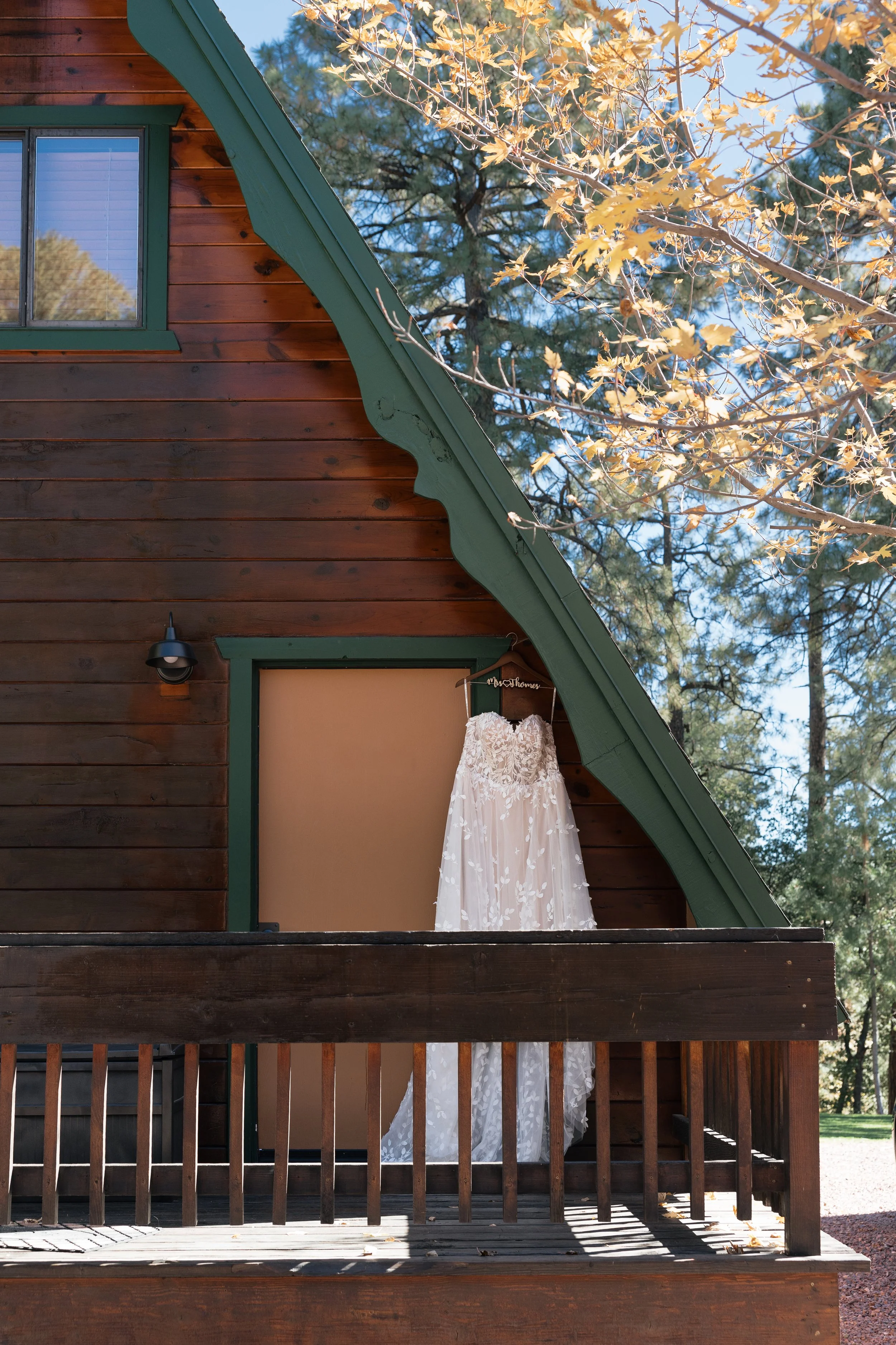 A wedding dress hanging on a a-frame cabin before a wedding at cabins on strawberry hill