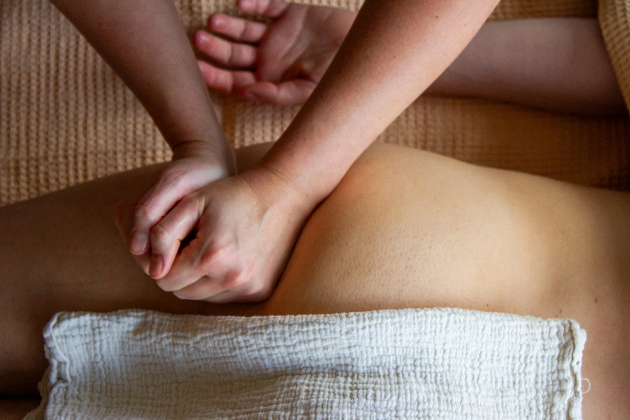 Persoon krijgt een massage op de rug in een ontspanningsruimte, met een doek over de onderrug.