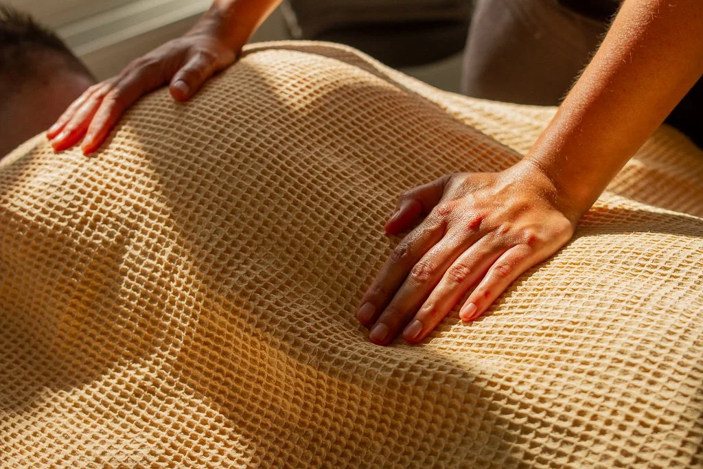 Handen op achterzijde lichaam, hartchakra en solarplexus.