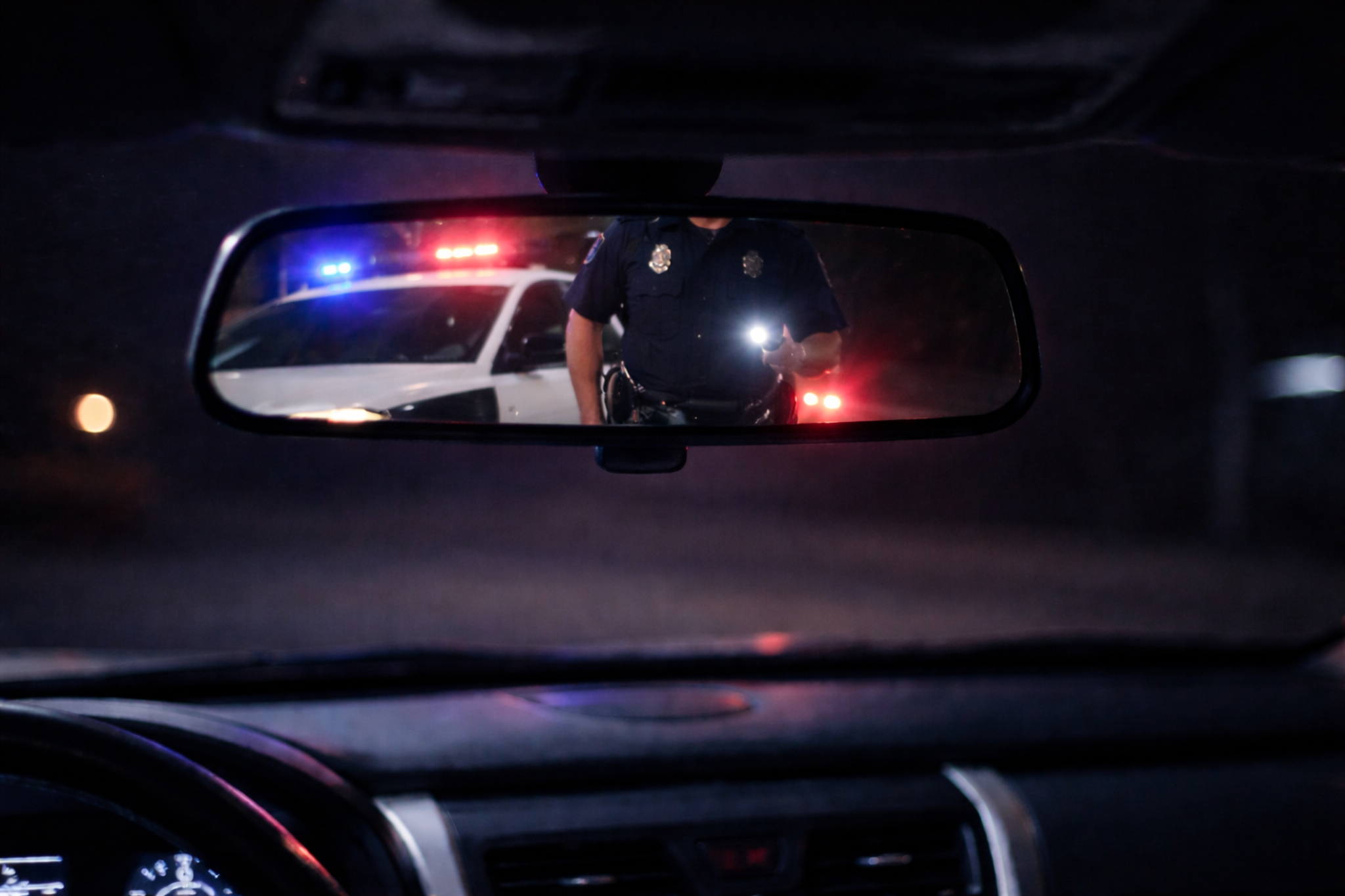 Police officer approaching vehicle during DUI traffic stop in Utah defended by criminal defense attorney Andrew McAdams