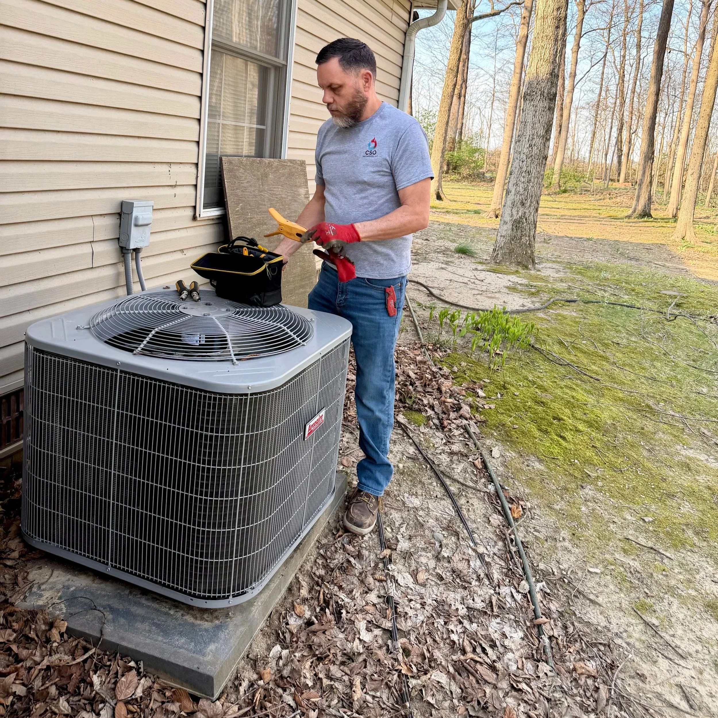 HVAC technician doing preventative maintenance on an air conditioning unit.