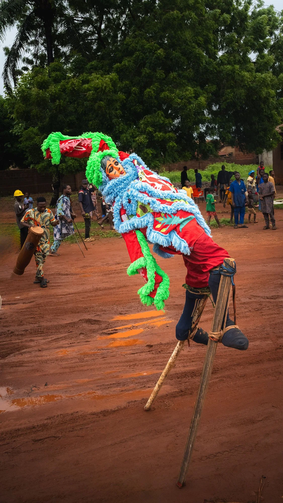 A cultural performer on stilts in Benin leans dangerously backward, almost parallel to the ground. This extraordinary moment of balance is an example of 'Positive Selection'—a keeper that pattern-matches for uniqueness and grit.