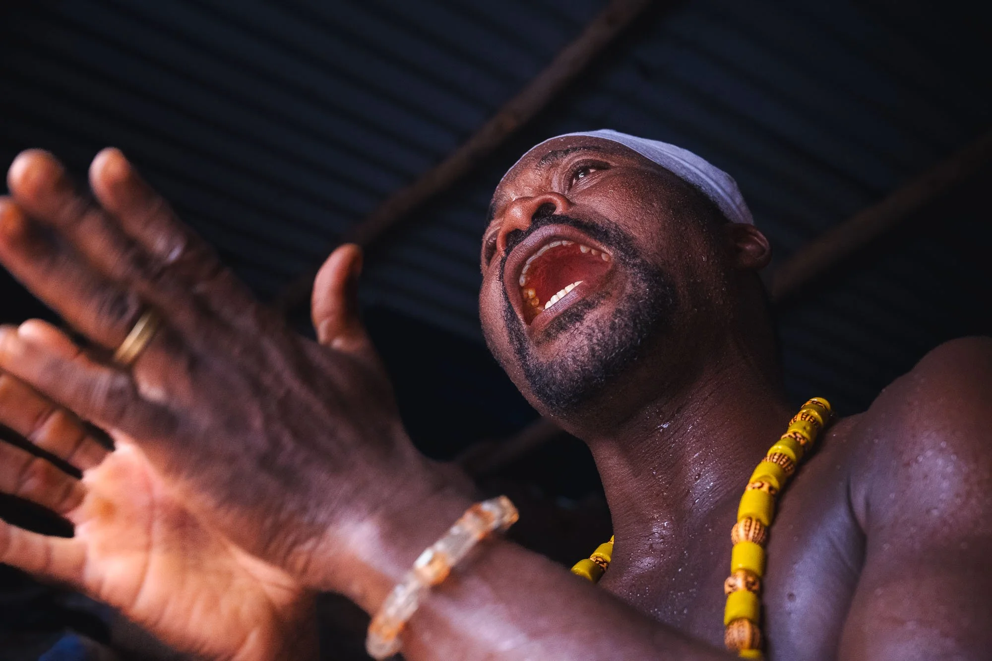 A powerful action portrait of a Mami Wata priest in Benin, West Africa, during a ritual, showing the importance of maintaining psychological distance in intense ethnographic environments.