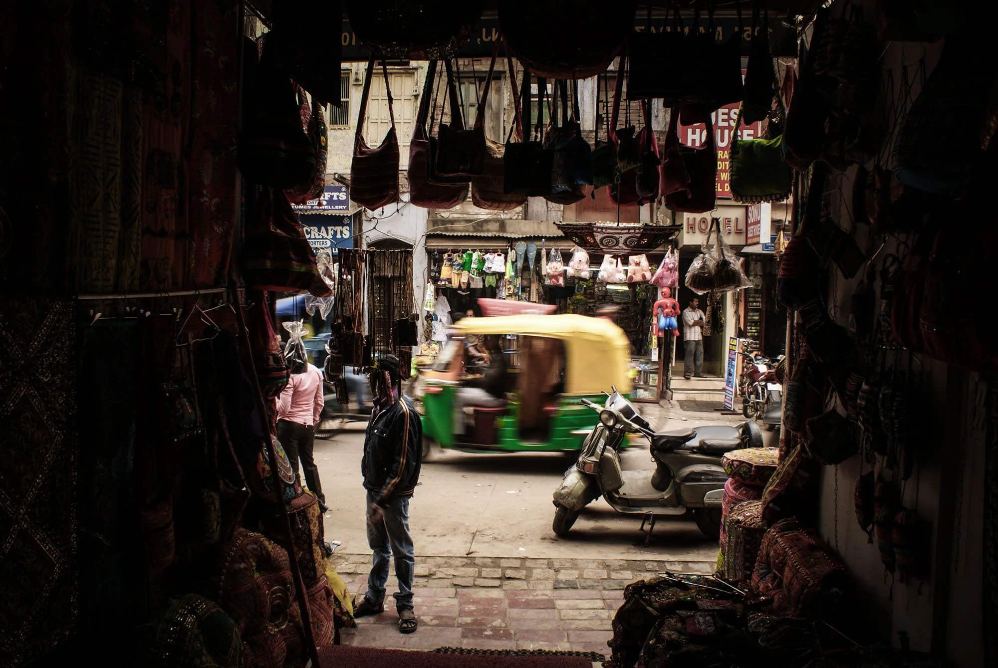 A busy street scene in India, with a blurred auto-rickshaw and dense environmental context. This image illustrates the 'Closed Loop' problem, where excessive visual information leads to cognitive boredom for the viewer