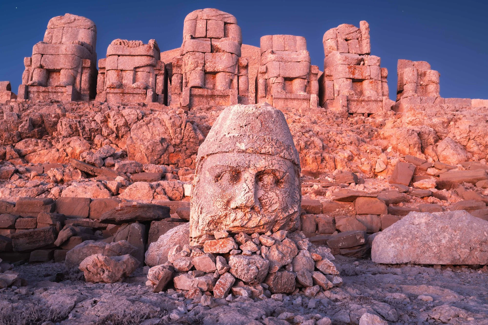 A close-up of a severed stone head of an ancient god at the summit of Mount Nemrut, Türkiye, used to illustrate the narrative fallacy in photography.