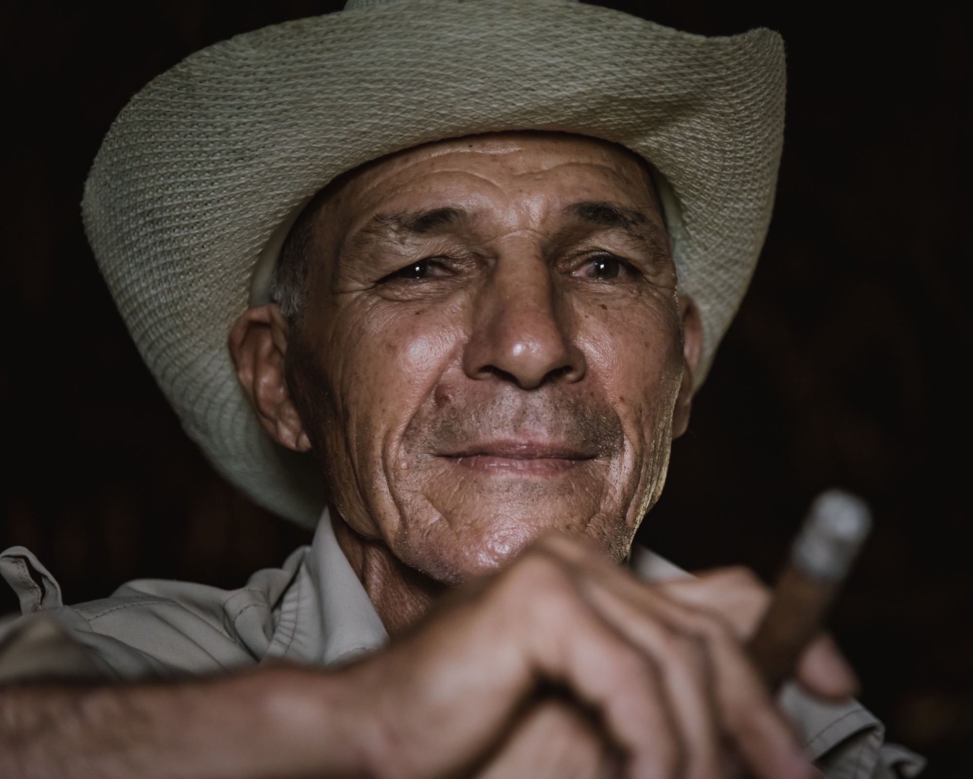 A gritty, character-driven portrait of a tobacco farmer in a cowboy hat smoking a cigar in Viñales, Cuba, used to explain the difference between affective and cognitive empathy.