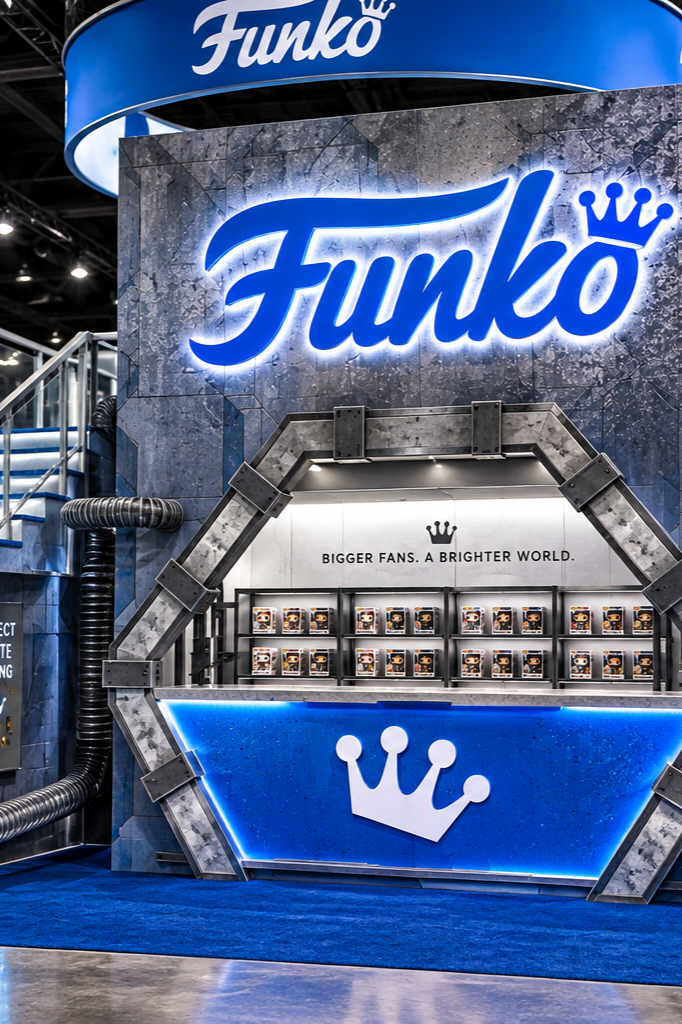 Booth display for Funko at an event, featuring a large illuminated Funko logo, a slogan 'BIGGER FANS. A BRIGHTER WORLD.' above a shelf with small Funko figures, and a blue counter with a crown logo.