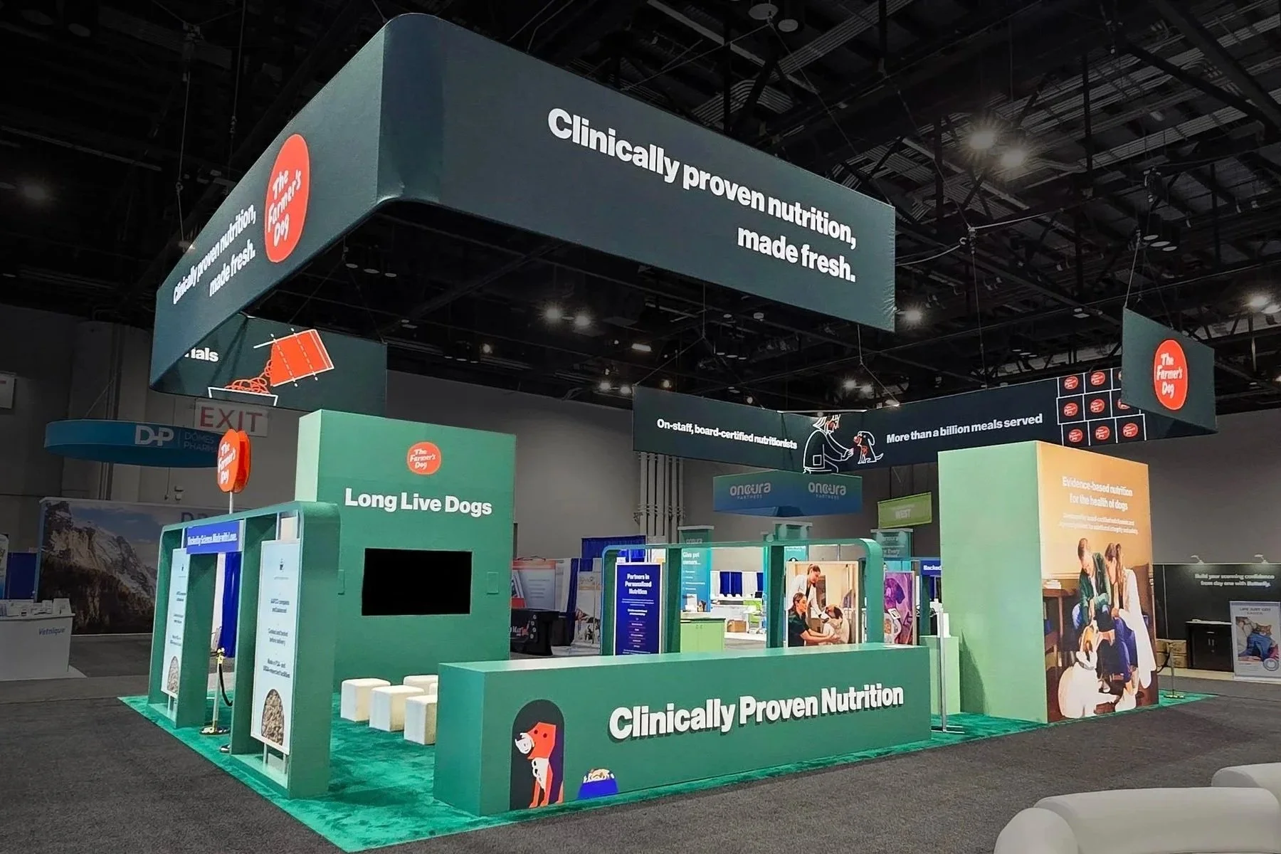 Exhibition booth with the company logo 'Cipia' displayed on a large hanging sign, featuring a blue and white color scheme, cars, monitors, and informational displays at a trade show.