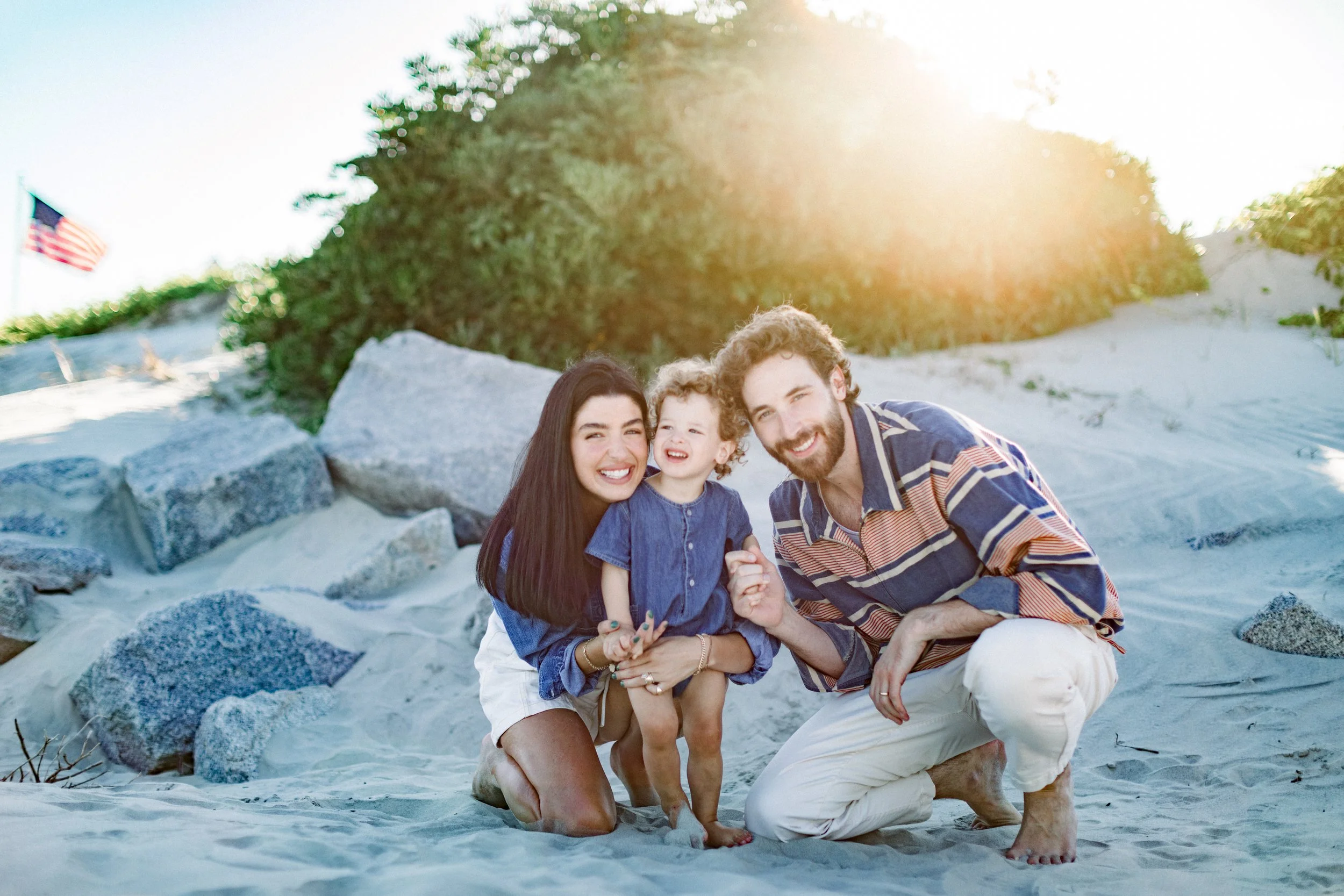 Family laughing together during golden hour session on Compo Beach in Westport, Connecticut