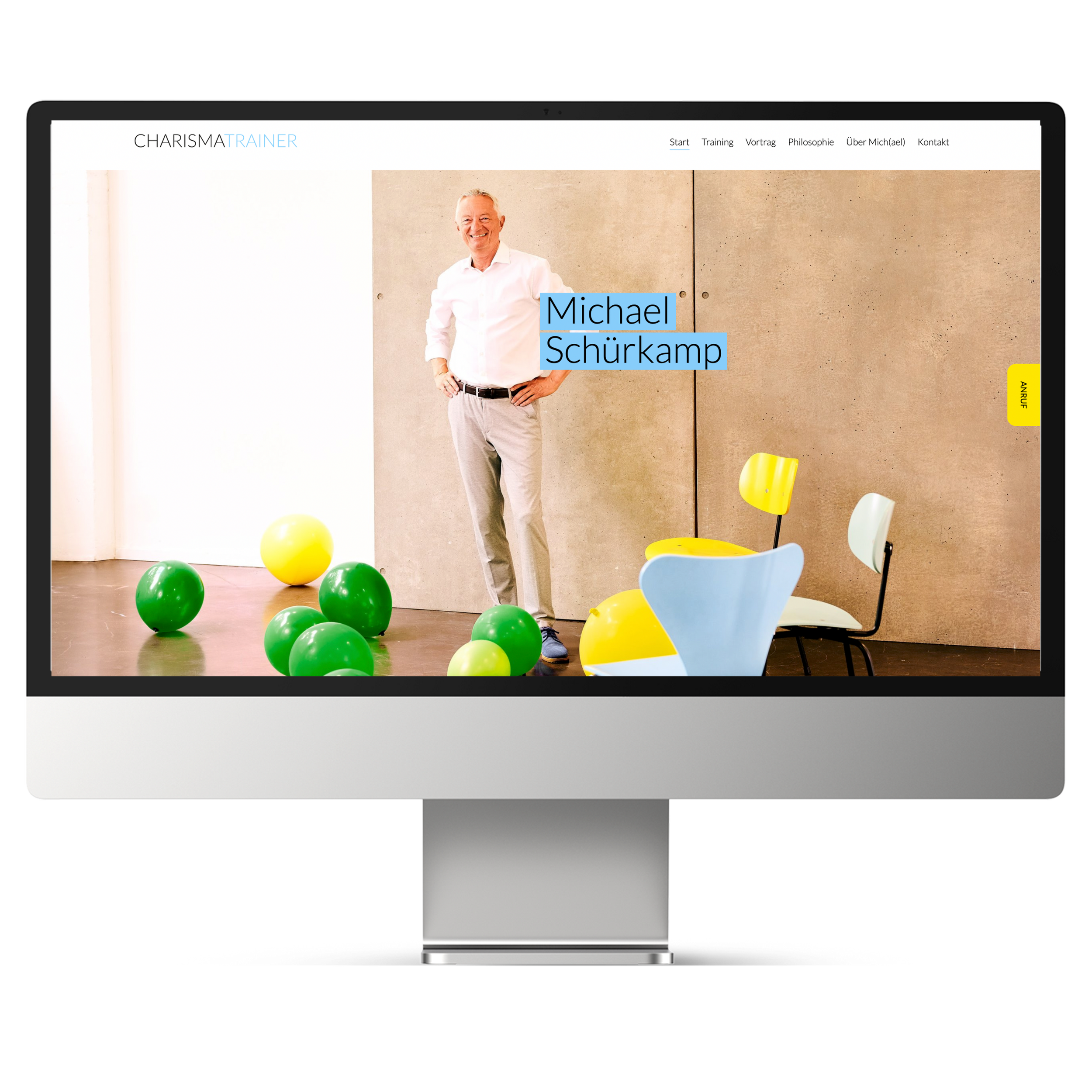 Ein Mann namens Michael Schürkamp steht vor einer beige Wand, umgeben von bunten Ballons und modernen Stühlen, auf einer Website namens Charisma Trainer.