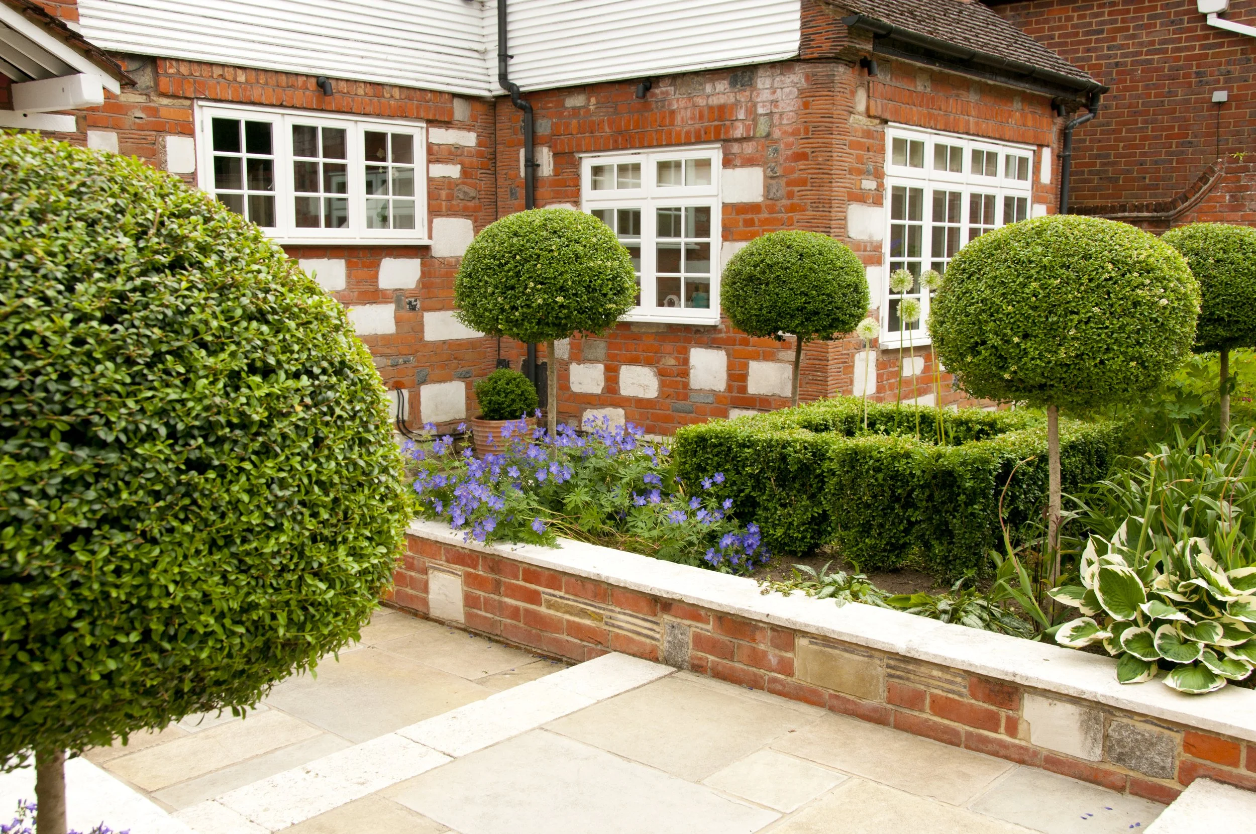 front garden in kent red brick borders green shrubs
