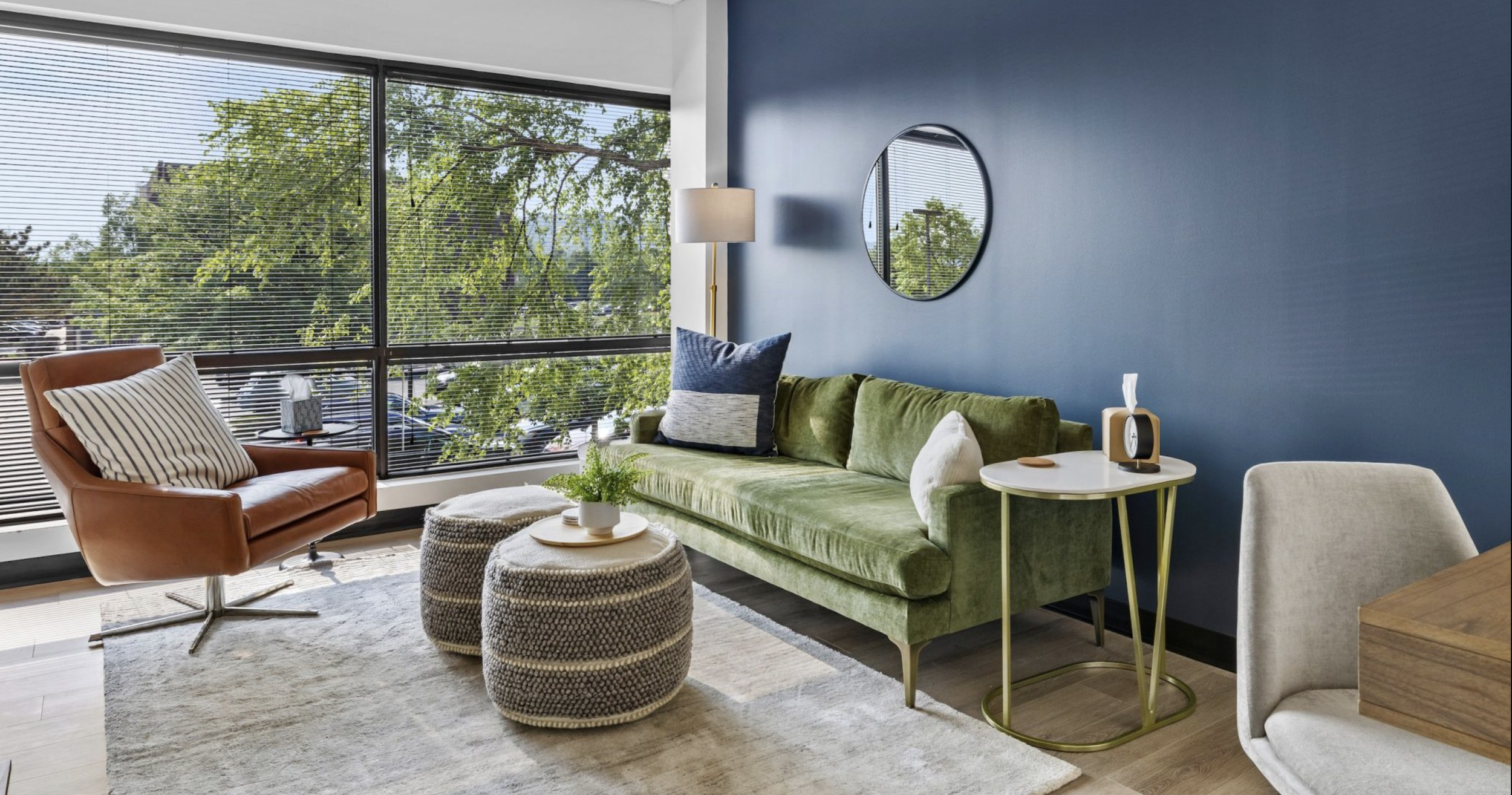 Modern room with green velvet sofa, beige armchair, and blue accent wall in Franklin, Tn | Couples Therapy & Anxiety Counseling | Clarity Therapy Franklin