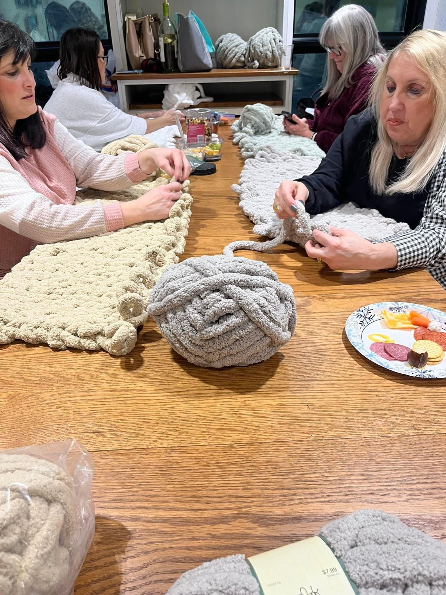 woman making finger knit blankets