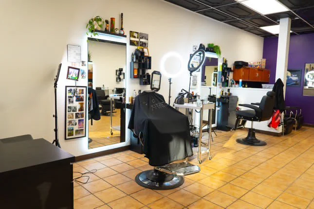 nterior of a modern barber shop xternalstudio located in clovis CA, mirror, and various hair styling tools. The room has tiled flooring and bright lighting.