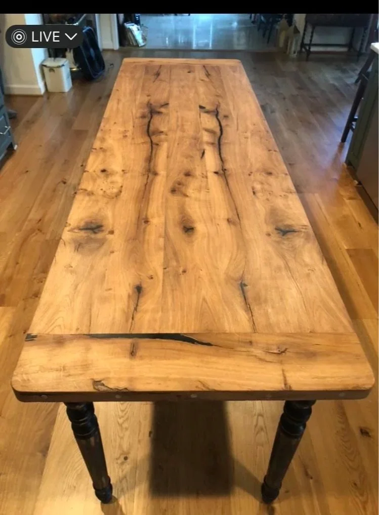 Wooden table with natural wood grain and knots in a room with hardwood floors.