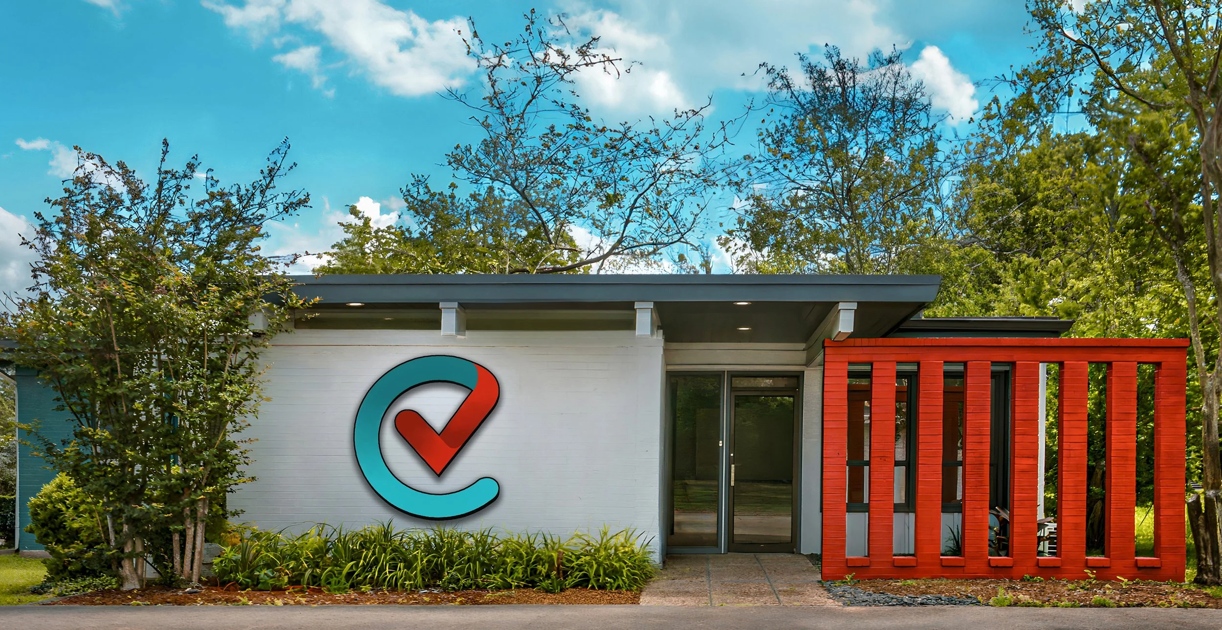 Exterior of a modern building with a logo featuring a red checkmark inside a blue circle on a white wall, surrounded by greenery, with a blue sky and clouds above.