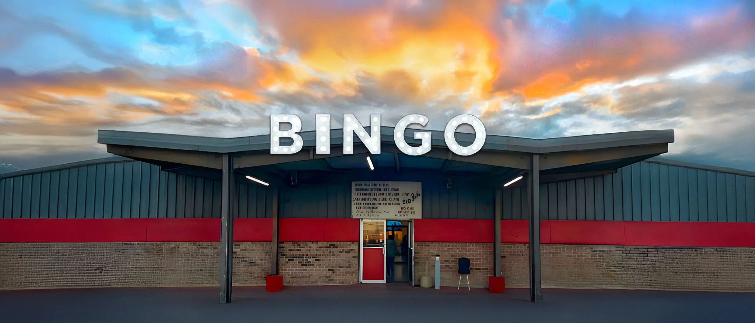 A bingo hall building with a large illuminated sign spelling 'BINGO' against a colorful sky at sunset.