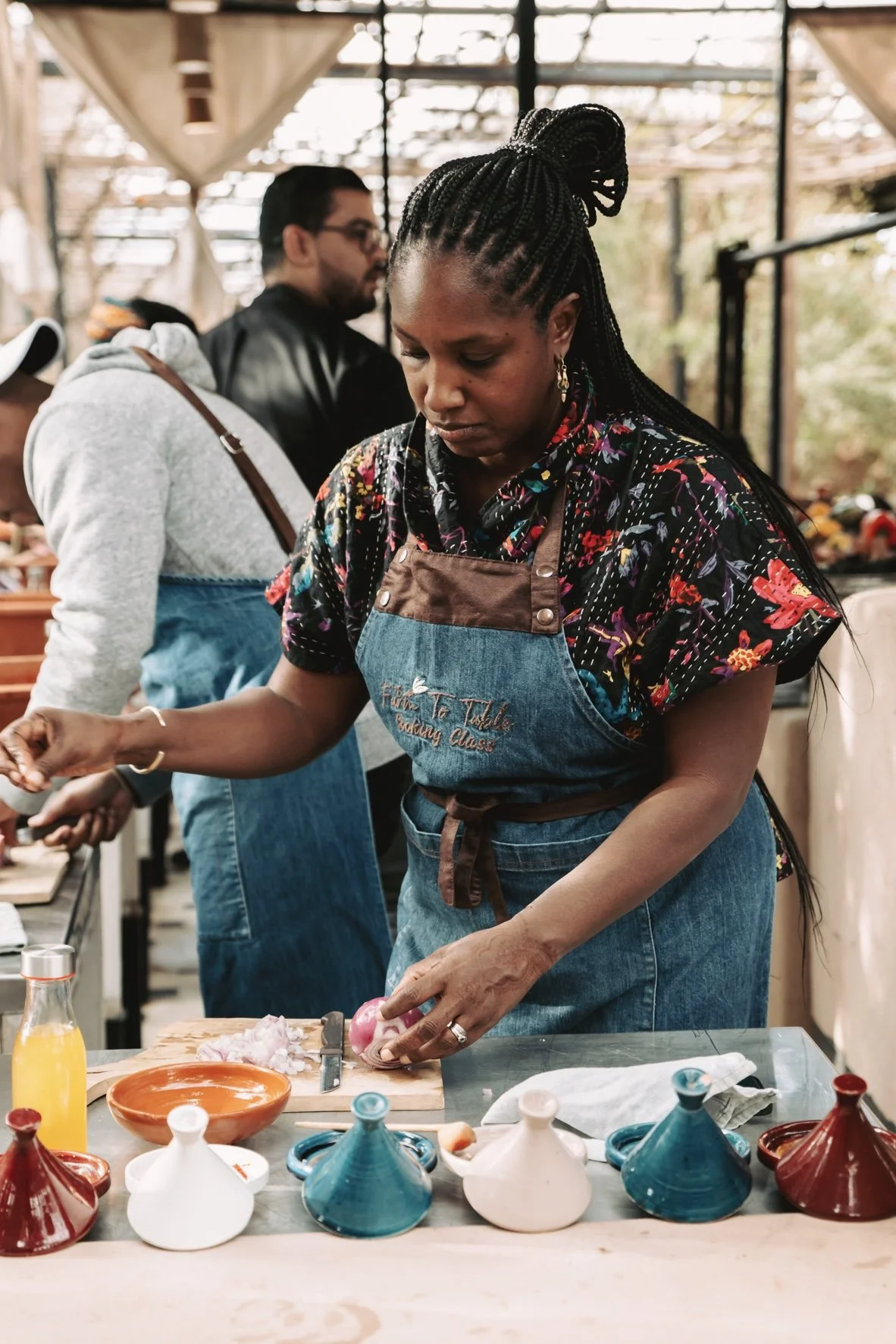 Jamila Crawford Pécou, vegan chef to the stars, chopping fresh ingredients at an outdoor kitchen/garden in an immersive global cuisine cooking class in Morocco, during EARTHCANDY ARTS retreat.