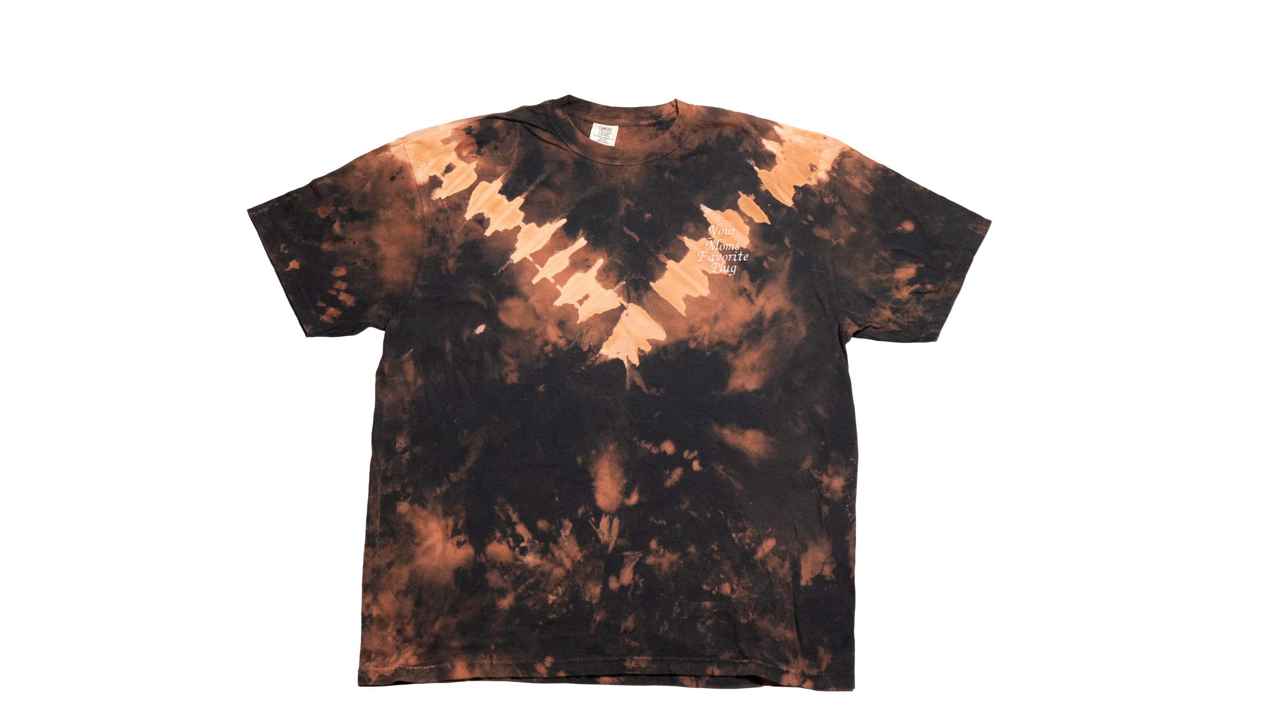 Front view of a black and coral bleach-dyed t-shirt with a V-shaped tie-dye pattern across the chest and shoulders. The upper left chest features small white text that reads “Your Moms Favorite Plug.”