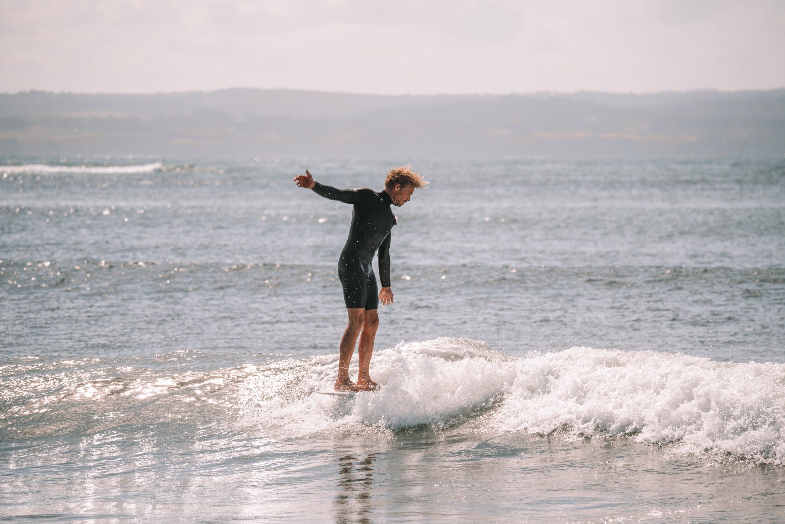 A man surfing on a wave at the beach.