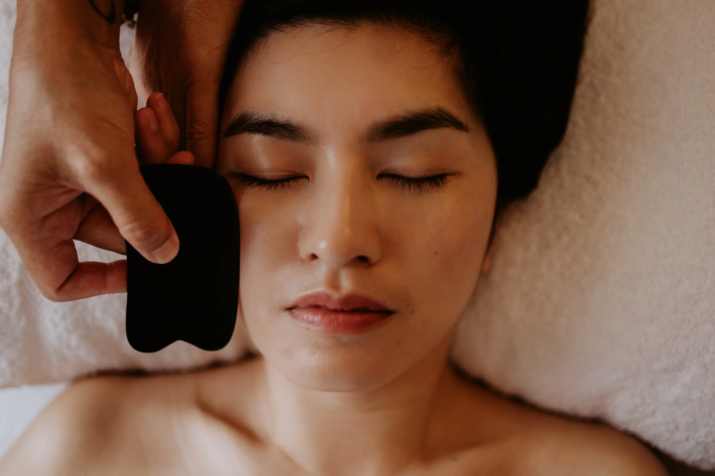A woman receiving facial guasha