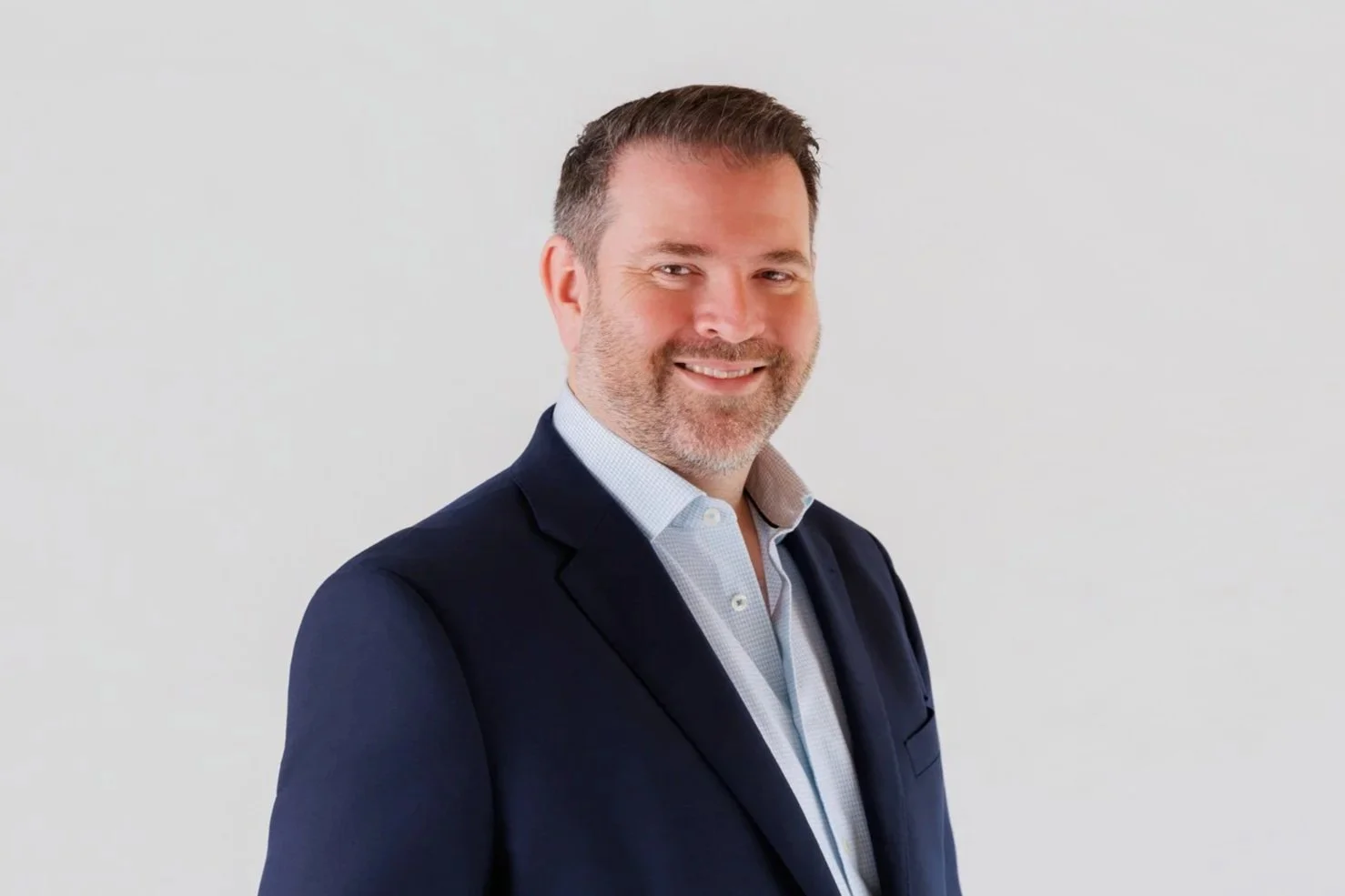 Andrew wearing a blue jacket and pale blue shirt