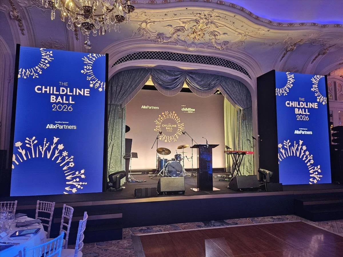 Stage set for a charity ball with lighting and screens