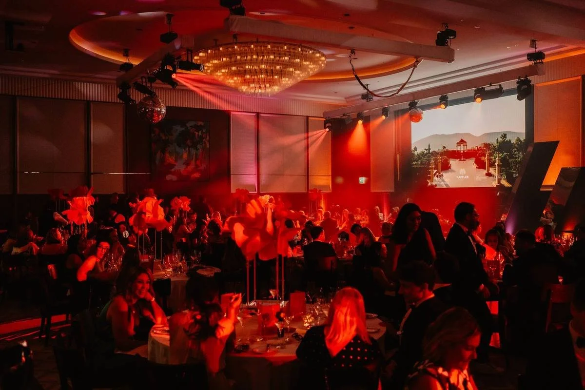 Awards dinner room with uplighting and a lit stage