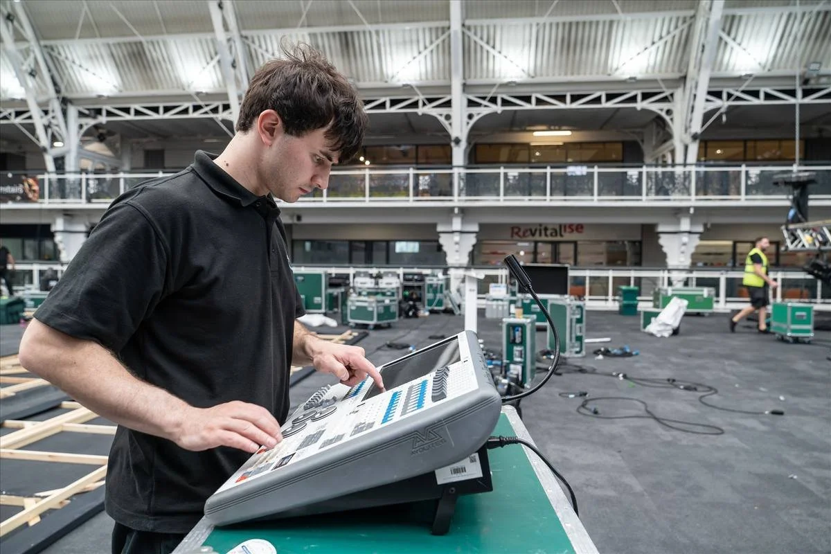 ASAS technician operating a lighting console at a venue control position
