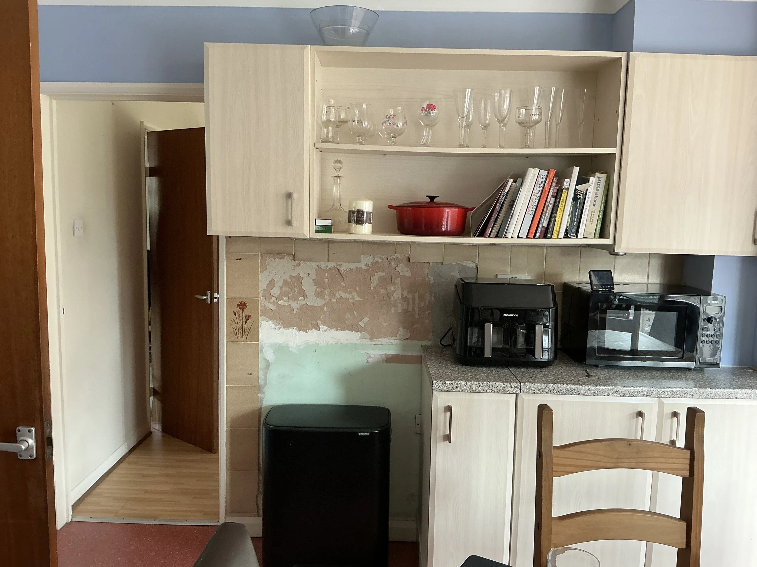 A kitchen with open fronted cabinets