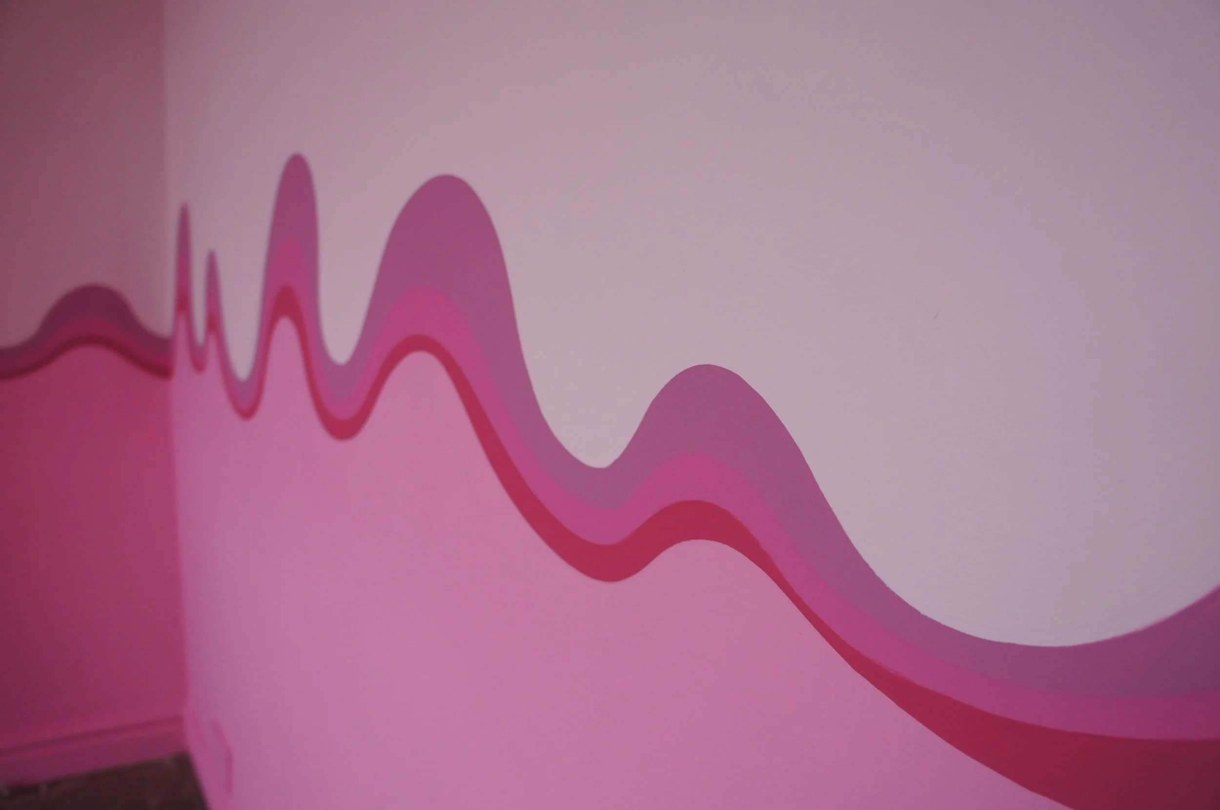 Pink swirly stripe painted on a bedroom wall