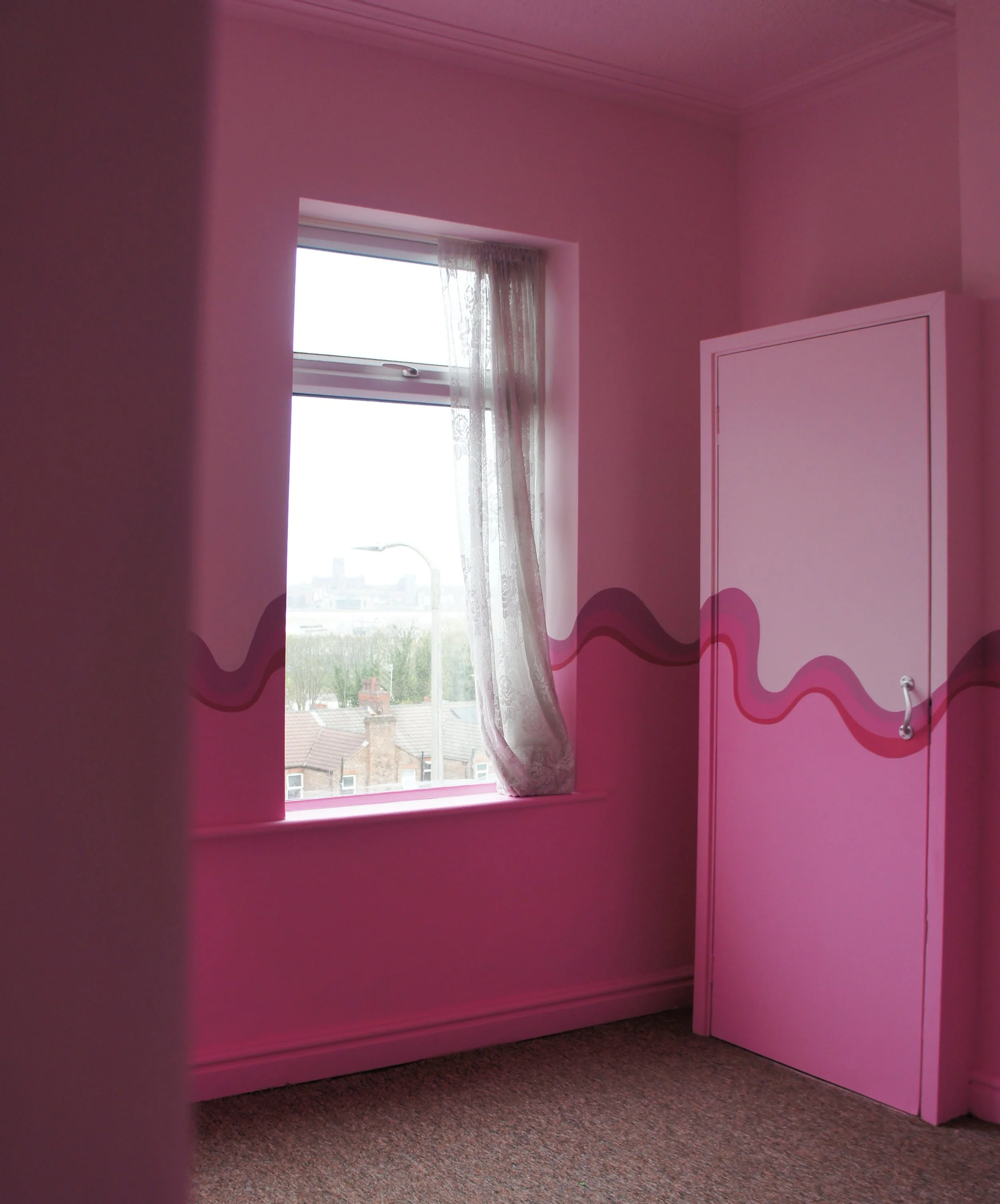 A pink bedroom with a bespoke swirly stripe across all walls and furniture
